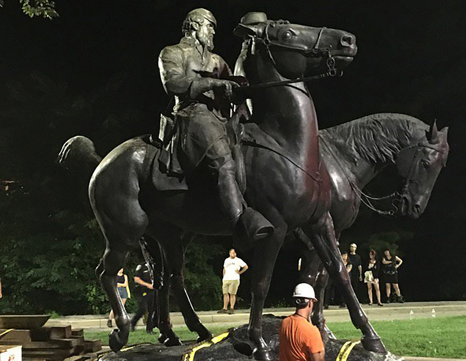 Workers load a statue of Confederate Gens. Robert E. Lee and Thomas "Stonewall" Jackson on a flatbed truck in the early hours of Wednesday in Baltimore. A campaign to remove symbols of the Civil War-era, pro-slavery secessionist republic is gathering momentum across the United States. (Alec MacGillis/AFP/Getty Images)