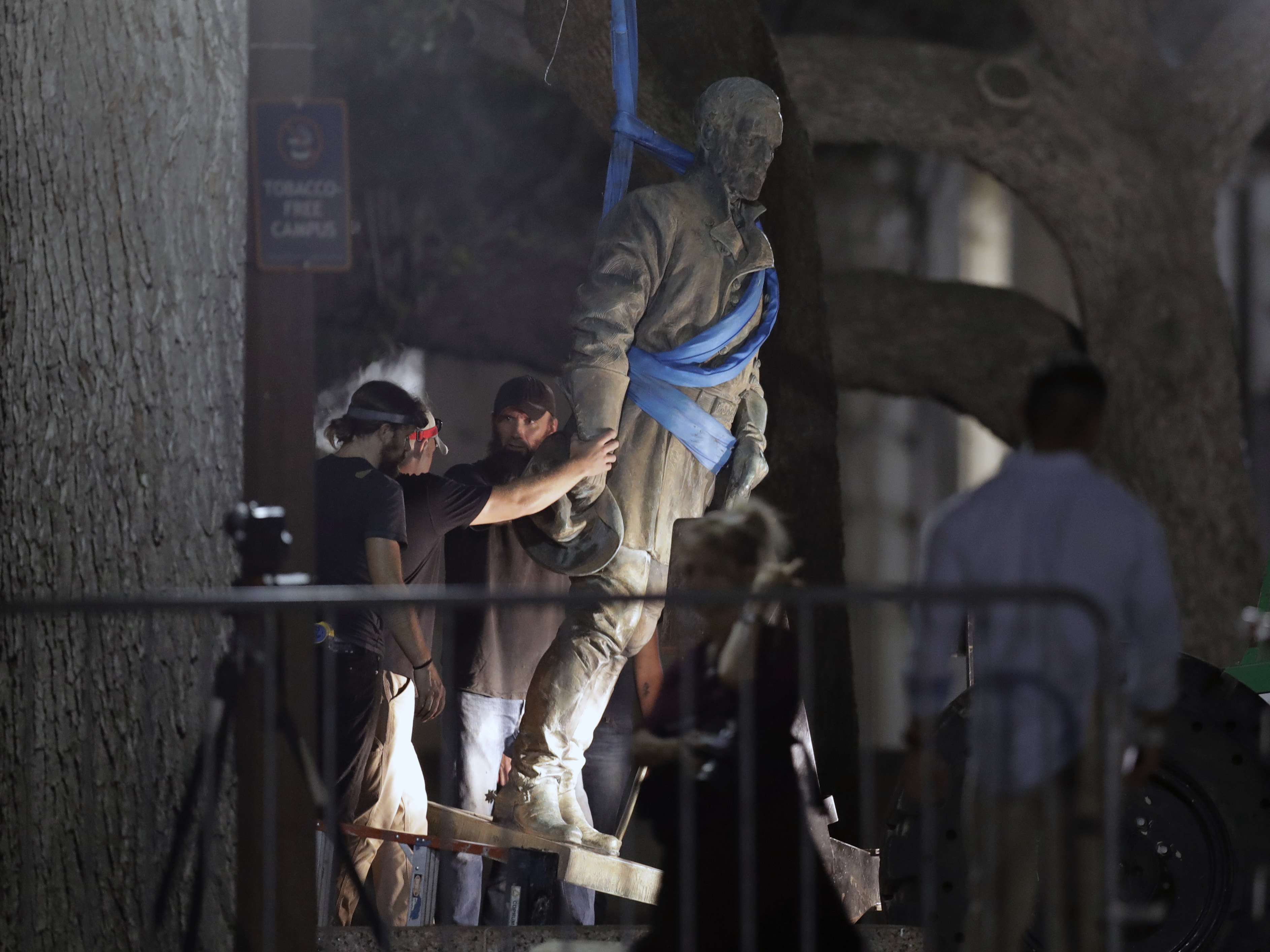 A statue of Confederate Gen. Robert E. Lee is removed from the University of Texas campus early Monday morning in Austin. University President Greg Fenves ordered the immediate removal of the Lee statue and three other prominent Confederate-era figures following recent violence in Charlottesville.