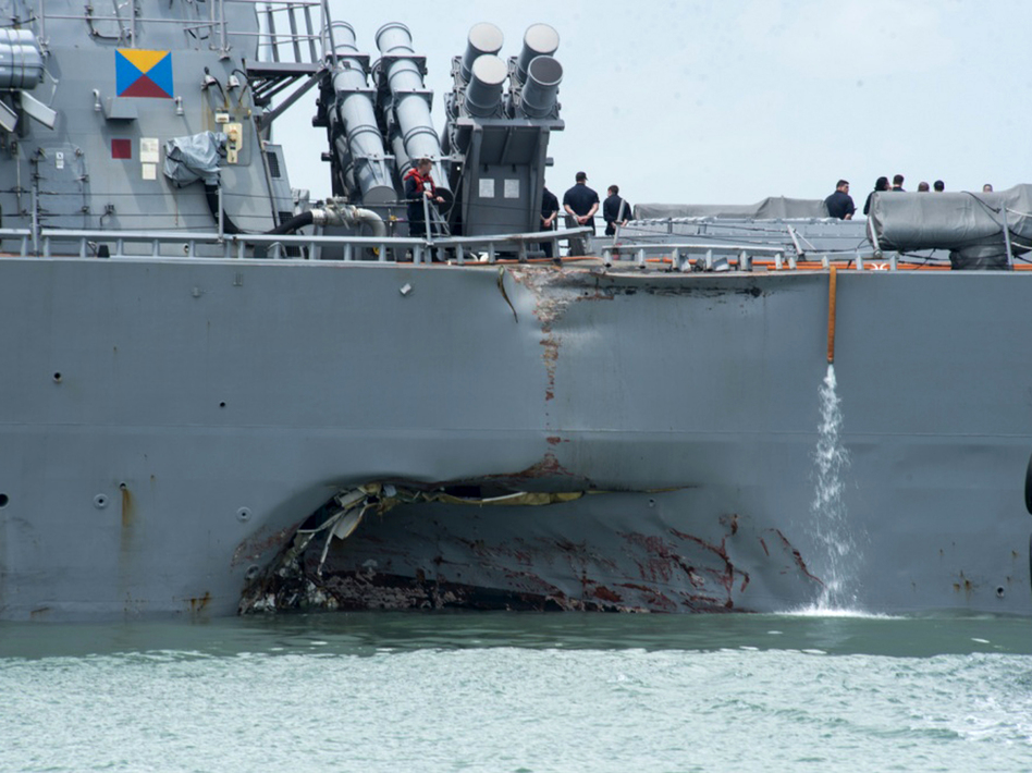 Damage to the port side is visible as the guided-missile destroyer USS John S. McCain steers toward Changi naval base in Singapore following a collision with the Alnic MC tanker on Monday. (Mass Communication Specialist 2nd Class Joshua Fulton/AP)
