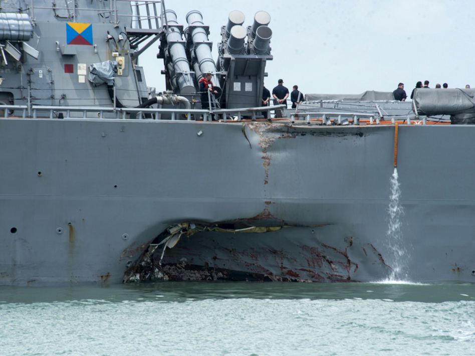 Damage to the port side is visible as the guided-missile destroyer USS John S. McCain steers toward Changi naval base in Singapore following a collision with the merchant vessel Alnic MC on Monday. (Mass Communication Specialist 2nd Class Joshua Fulton/AP)
