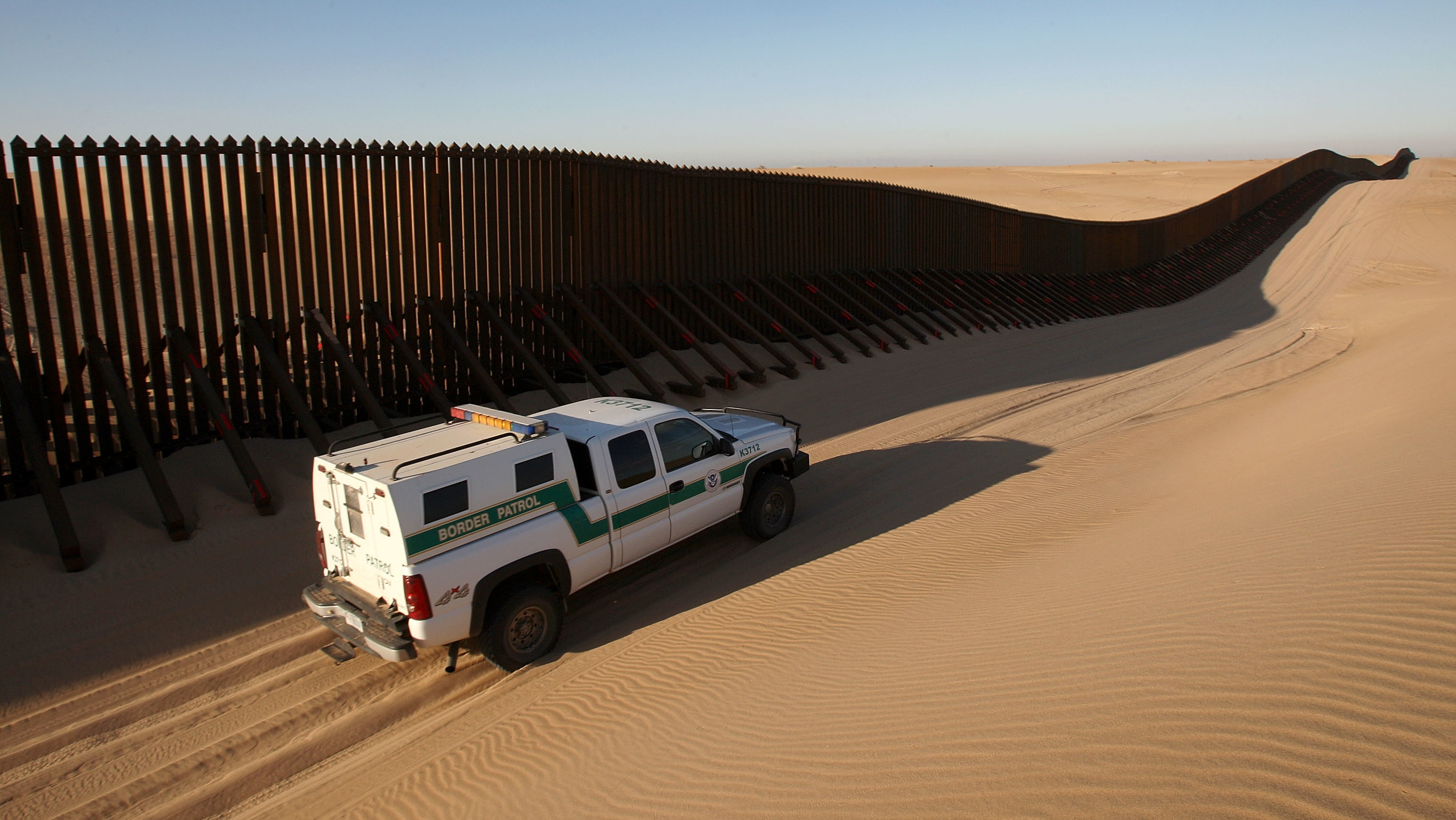 A Border Patrol vehicle patrols a section of the U.S.-Mexico border fence near Yuma, Ariz. (Getty Images)