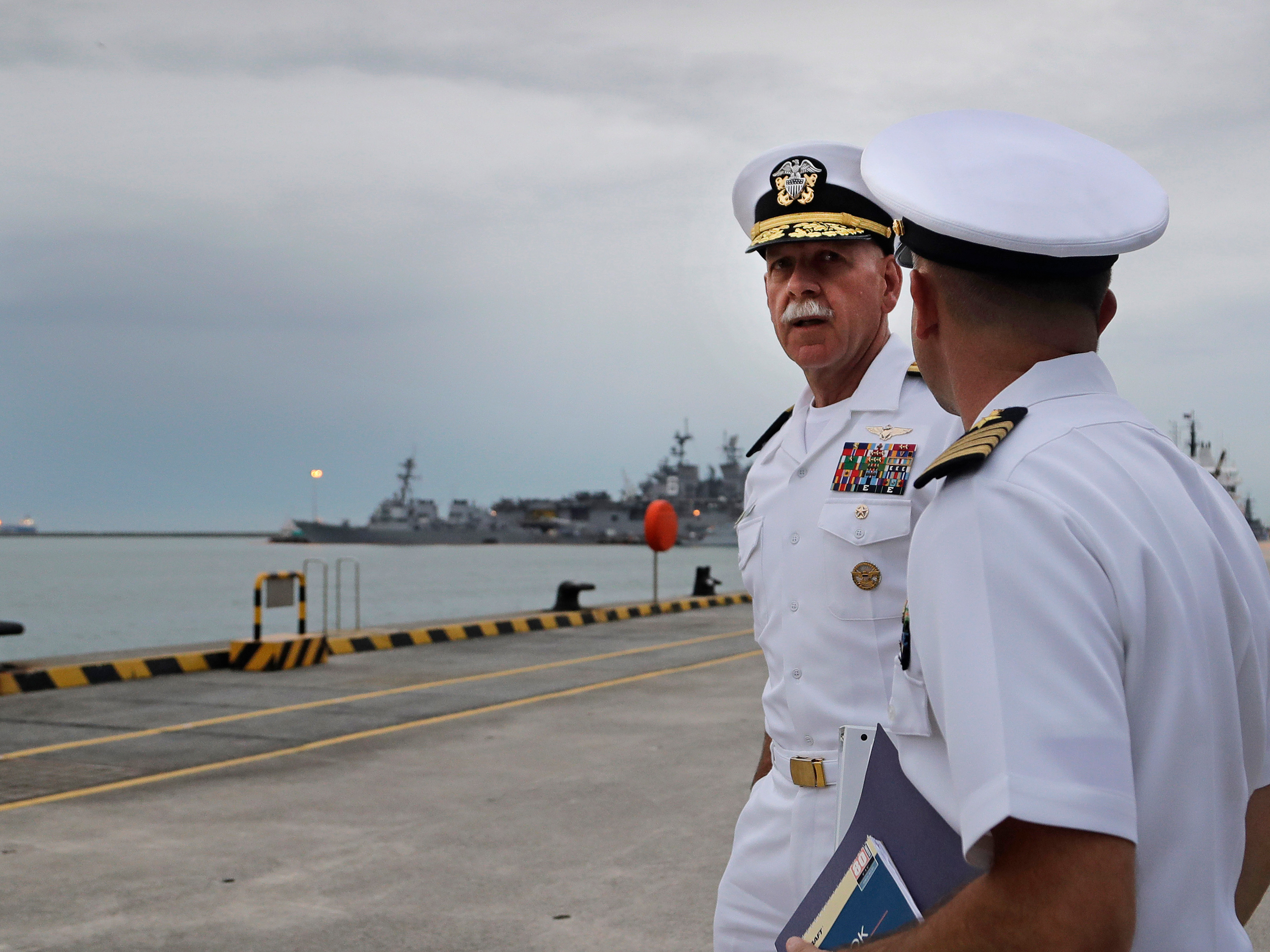 Commander of the U.S. Pacific Fleet, Scott Swift, left, before a press conference on Tuesday. The USS John S. McCain, left, and USS America are docked in the background at Singapore's Changi naval base. (Wong Maye-E/Associated Press)