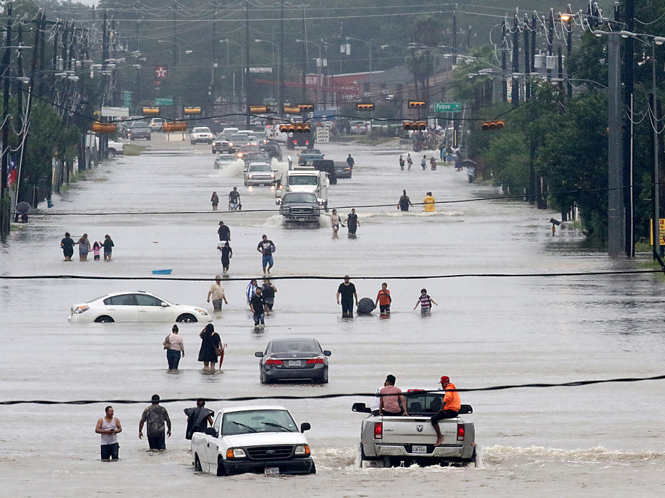 People walk through floodwaters on Telephone Road in Houston on Sunday after 2 feet of rain from Hurricane Harvey pummeled the Gulf Coast. (Thomas B. Shea/AFP/Getty Images)