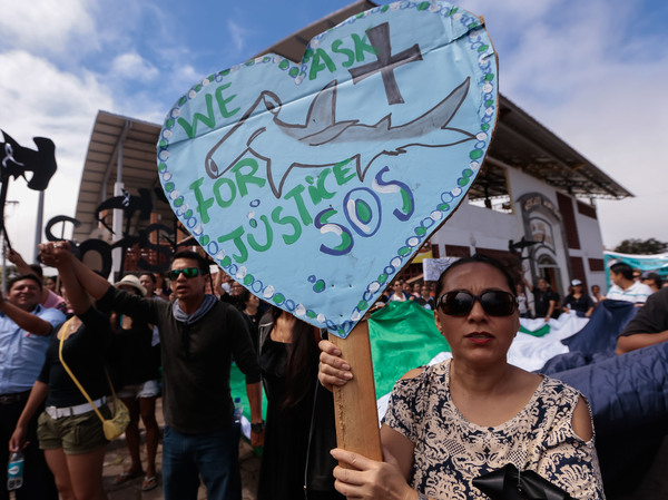 Residents of the Galápagos Islands demonstrate outside the court where the crew of the Chinese-flagged ship had a hearing last week. The Ecuadorean navy earlier this month seized the ship, which had been carrying some 300 tons of fish, including several endangered species such as the hammerhead shark.