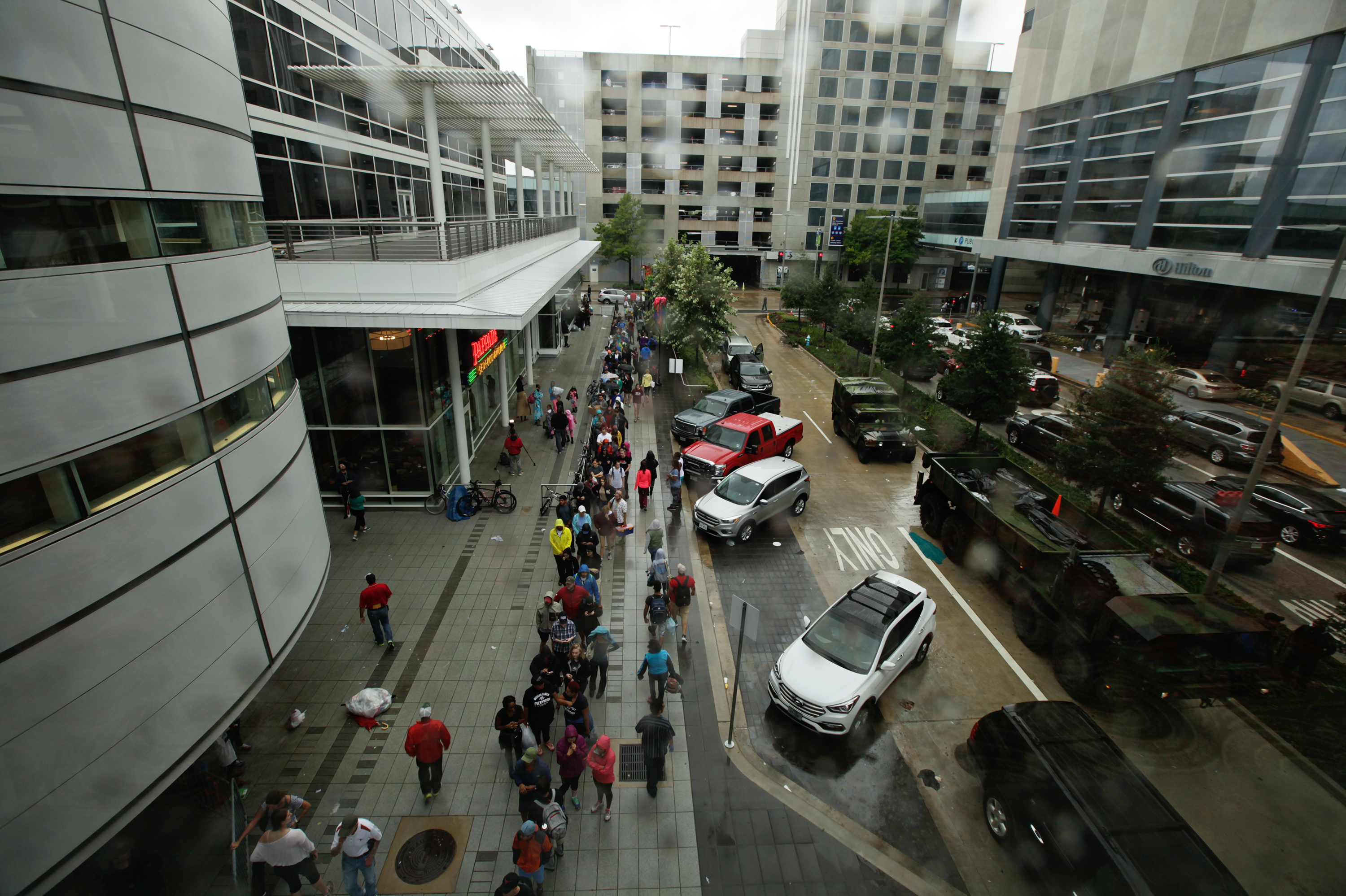 Lines of people wait outside the George R. Brown Convention Center, which has been turned into a shelter for people seeking refuge from Tropical Storm Harvey, in downtown Houston. (NPR)
