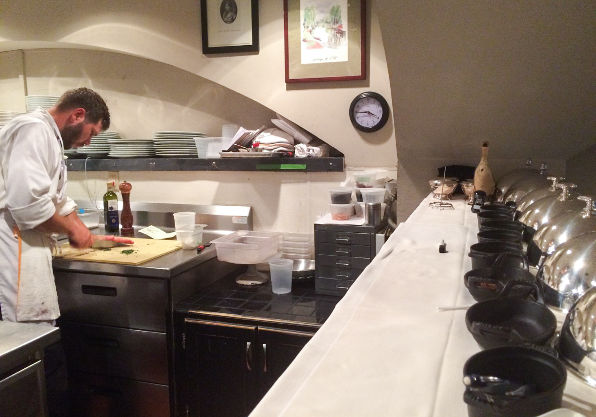 David Uzzell at work in the kitchen at Marcel's. Uzzell has a written list of daily tasks from chef and owner Robert Wiedmaier at his station, and his ever-present notepad and pencil on the shelf above serves as communication tools for more specific instructions. (Kristen Hartke for NPR)