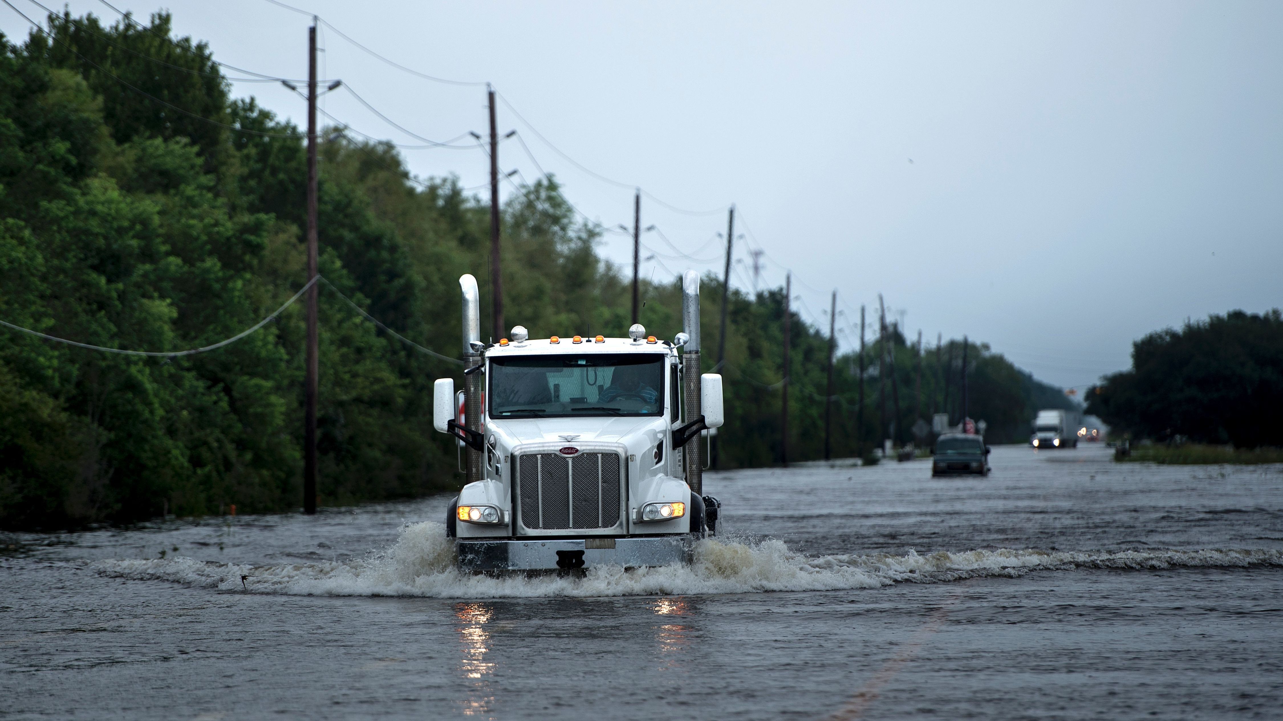 Trucks make their way through floodwaters on a road leading to Arkema Inc. in Crosby, Texas, Wednesday. Chemicals at the plant are in danger of exploding because refrigeration is out owing to Hurricane Harvey. (AFP/Getty Images)