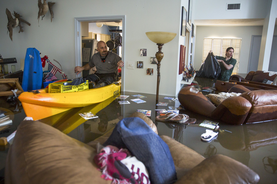 Larry Koser Jr. (left) and his son, Matthew, look for important papers and heirlooms inside his house after it was flooded by heavy rains from Hurricane Harvey. (Erich Schlegel/Getty Images)