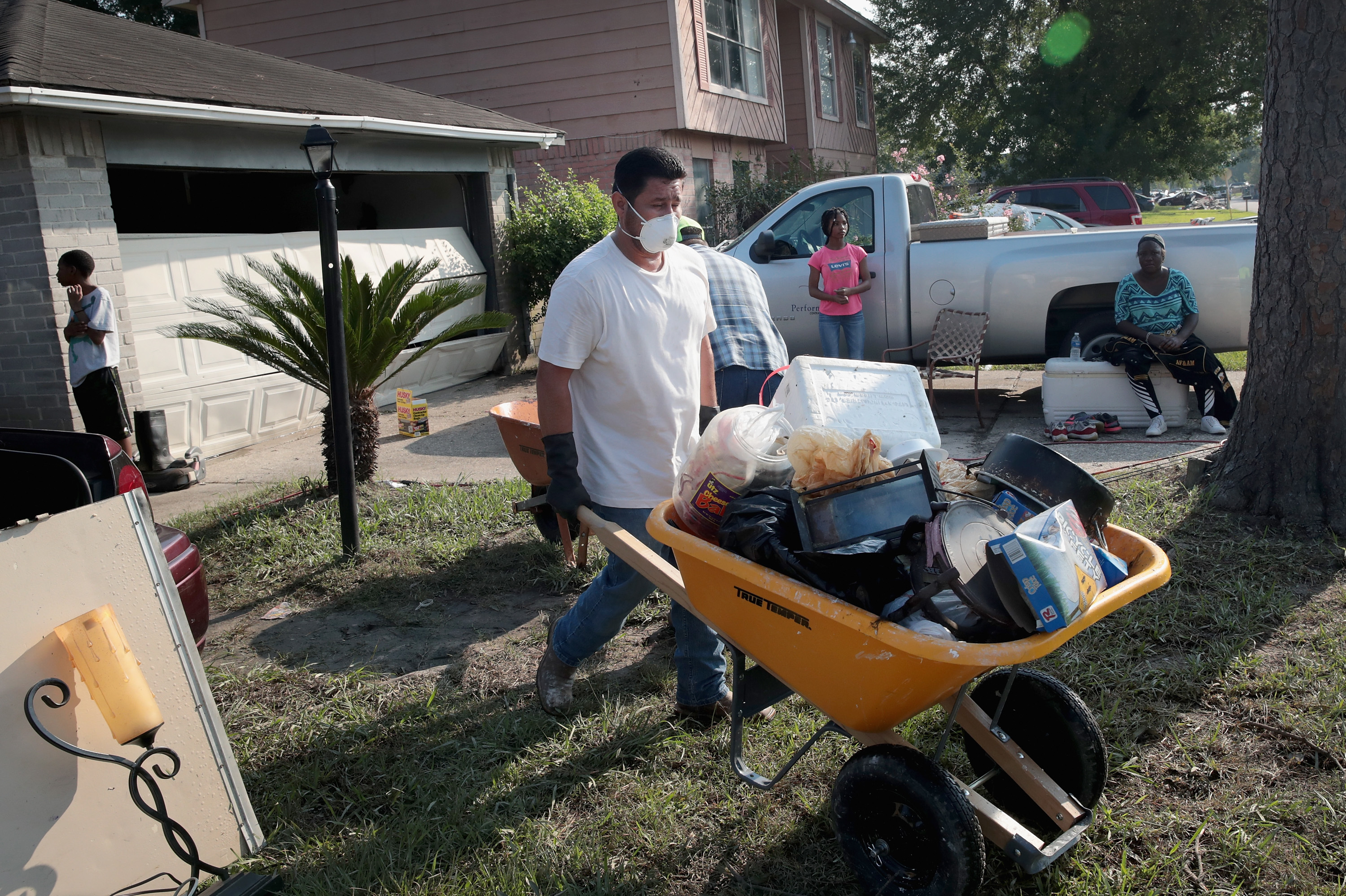 Volunteers from Performance Contractors help co-worker Cornell Beasley deal with Harvey-related water damage to his home in Houston on Friday. (Getty Images)