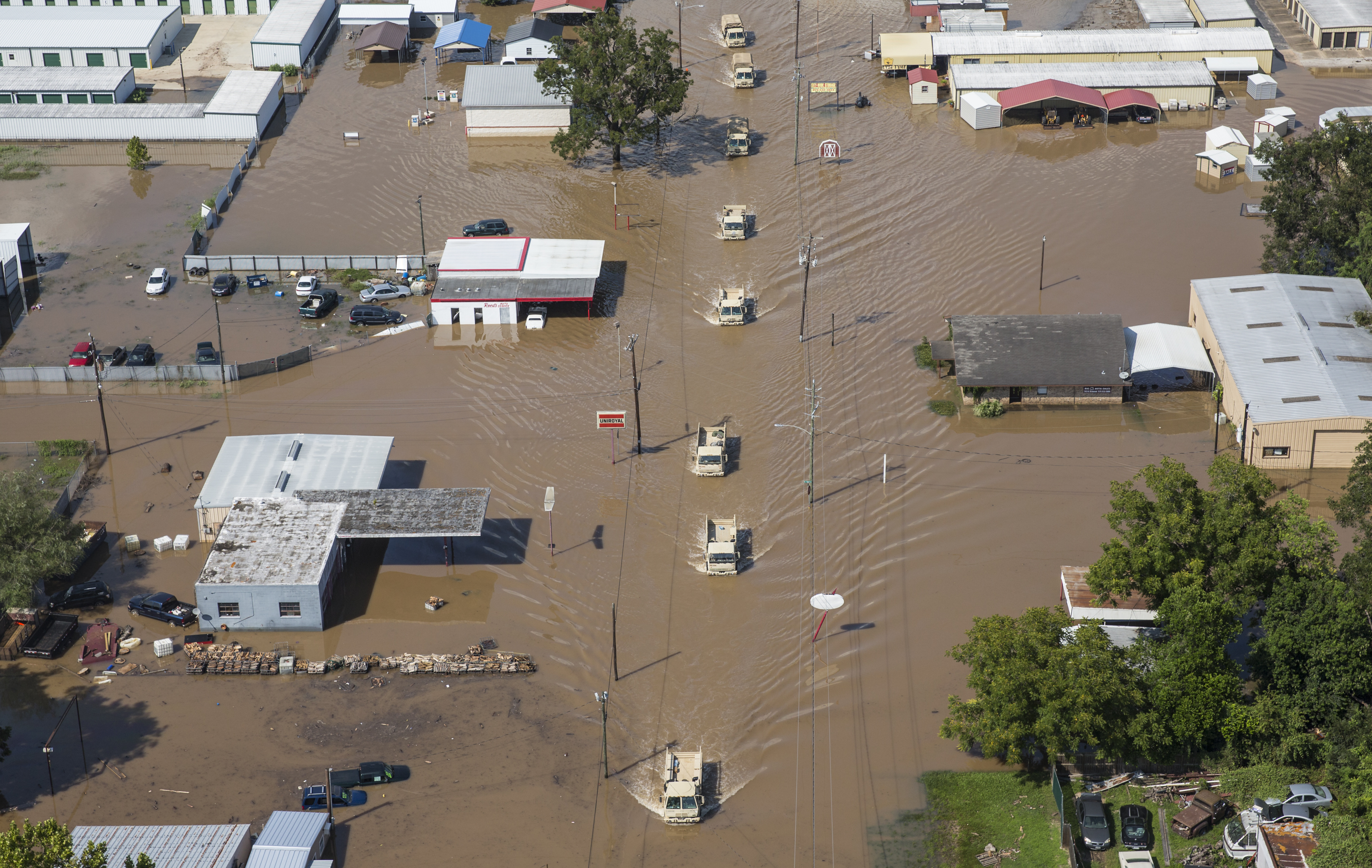 National Guard vehicles drive down a flooded street in Wharton, Texas, on Friday.
