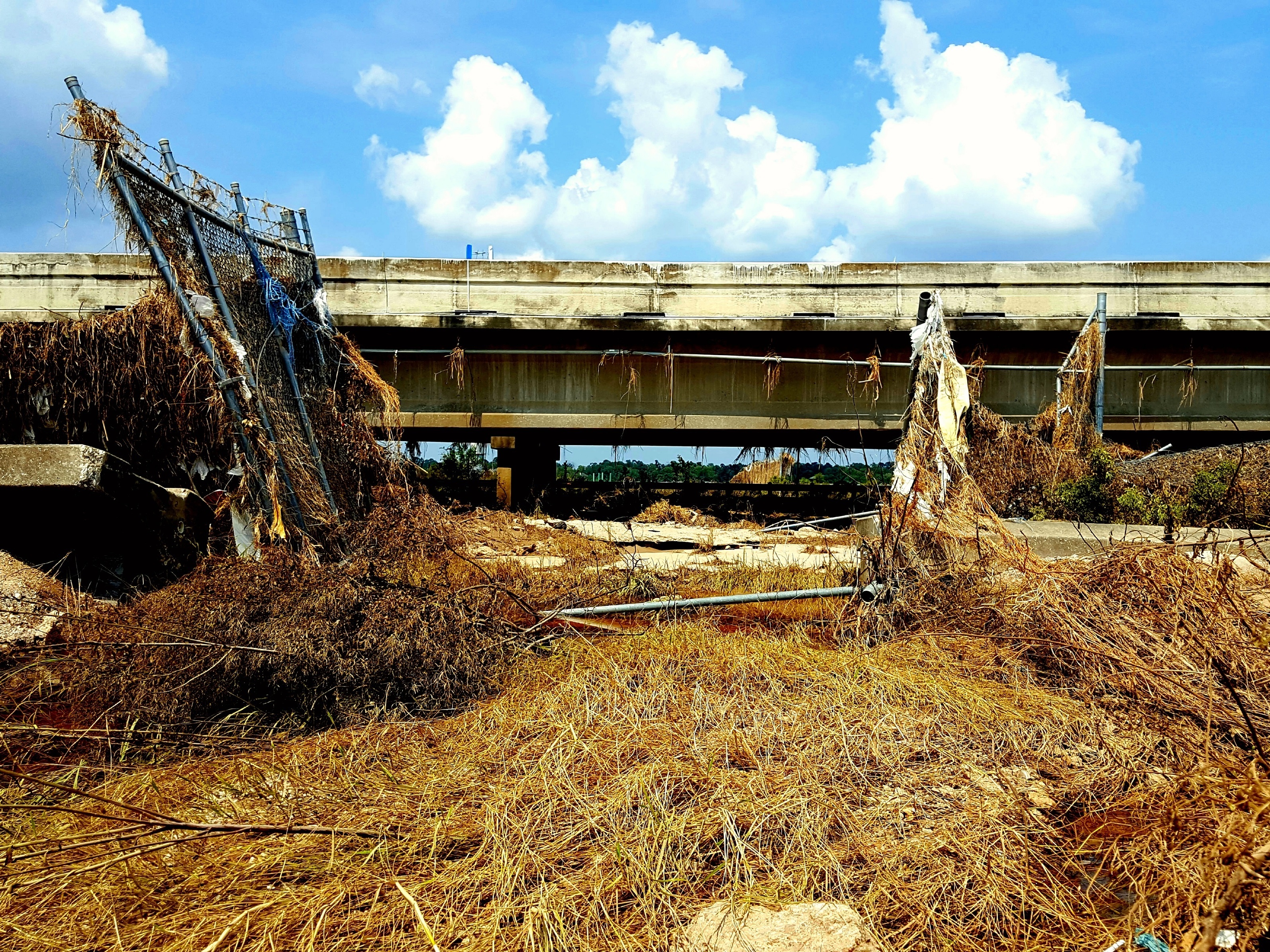 Floodwater from last week's storm ripped apart fences and flooded I-10. The San Jacinto Waste Pits Superfund site is just on the other side of the road. (NPR)