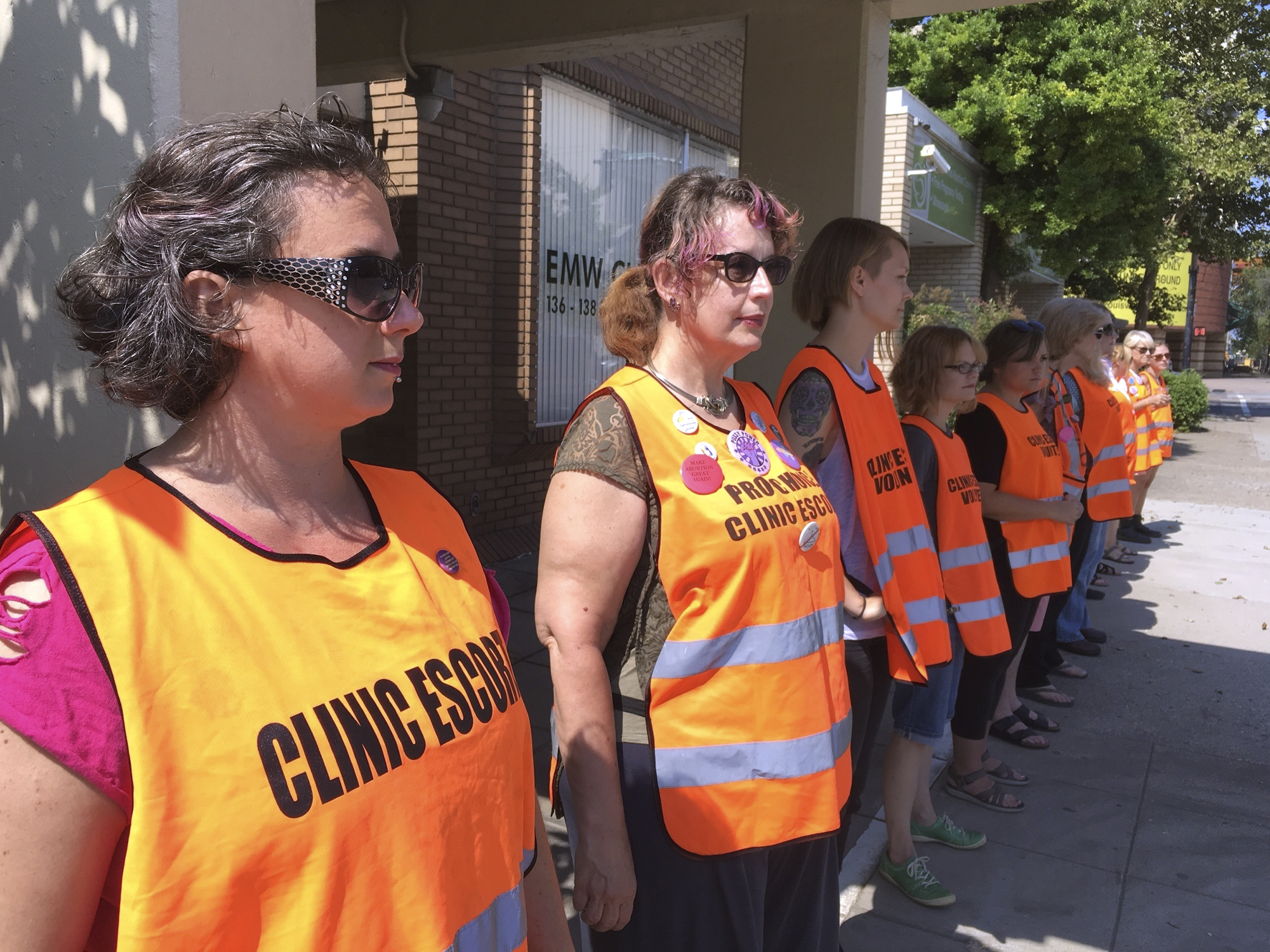 Volunteer escorts line up outside the EMW Women's Surgical Center in Louisville, Ky., ahead of a large anti-abortion-rights protest earlier this summer.