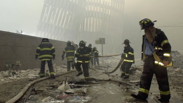 Firefighters work beneath the vertical struts of the World Trade Center