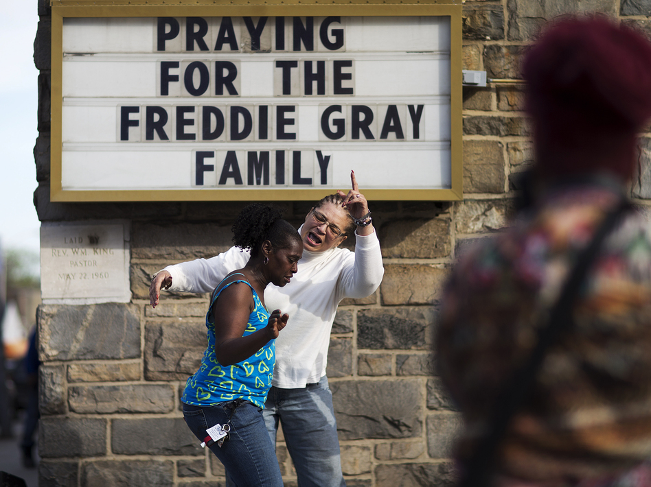 Women dance and pray to music over a loudspeaker outside a church following the funeral for Freddie Gray in 2015. (David Goldman/AP)