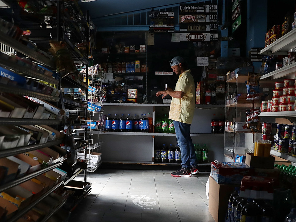 A person visits a Miami store that doesn't have electricity on Tuesday. Much of Florida was without power two days after Hurricane Irma battered the state. (Joe Raedle/Getty Images)