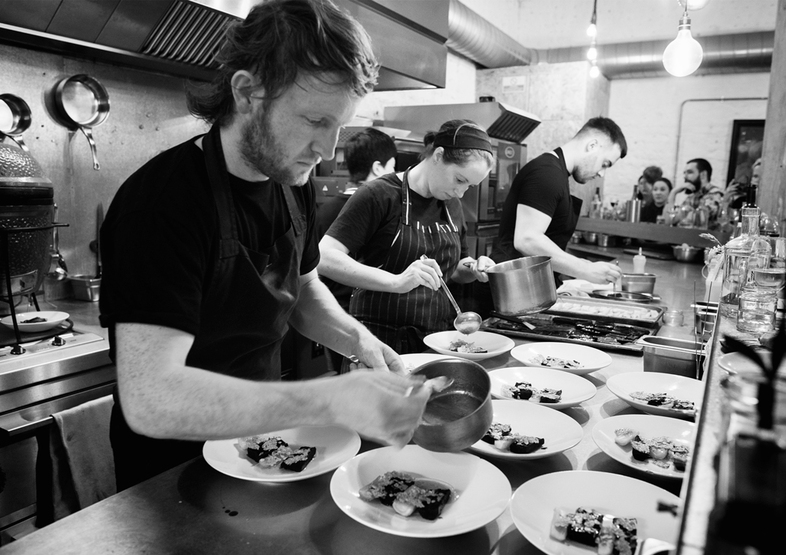 Chef Douglas McMaster is committed to a "zero waste" ethos in his restaurants. Here, he plates up his creations at Silo, his flagship restaurant, in Brighton, England, about an hour south of London. (Xavier Buendia/Courtesy of Doug McMaster)