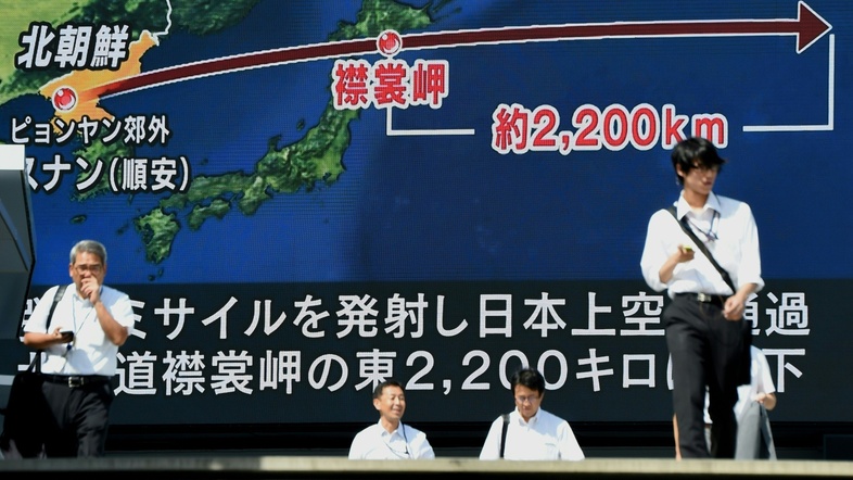 Pedestrians walk in front of a large video screen in Tokyo broadcasting a news report about North Korea's latest missile test that passed over Japan early Friday morning. (Toru Yamanaka /AFP/Getty Images)