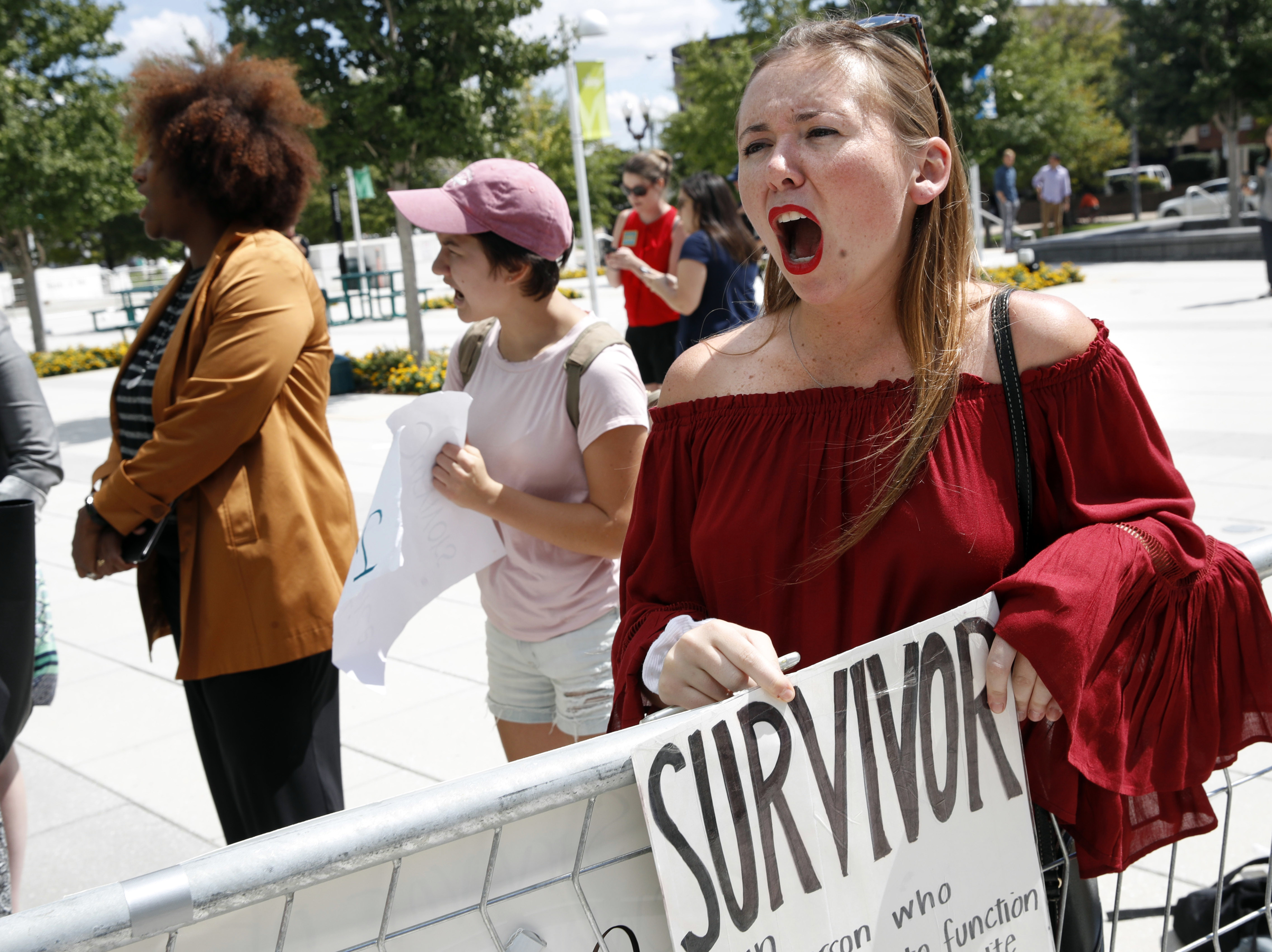 Meghan Downey, 22, a recent graduate from the College of William & Mary, protests outside an Arlington, Va., auditorium after Education Secretary Betsy DeVos spoke about campus sexual assault.