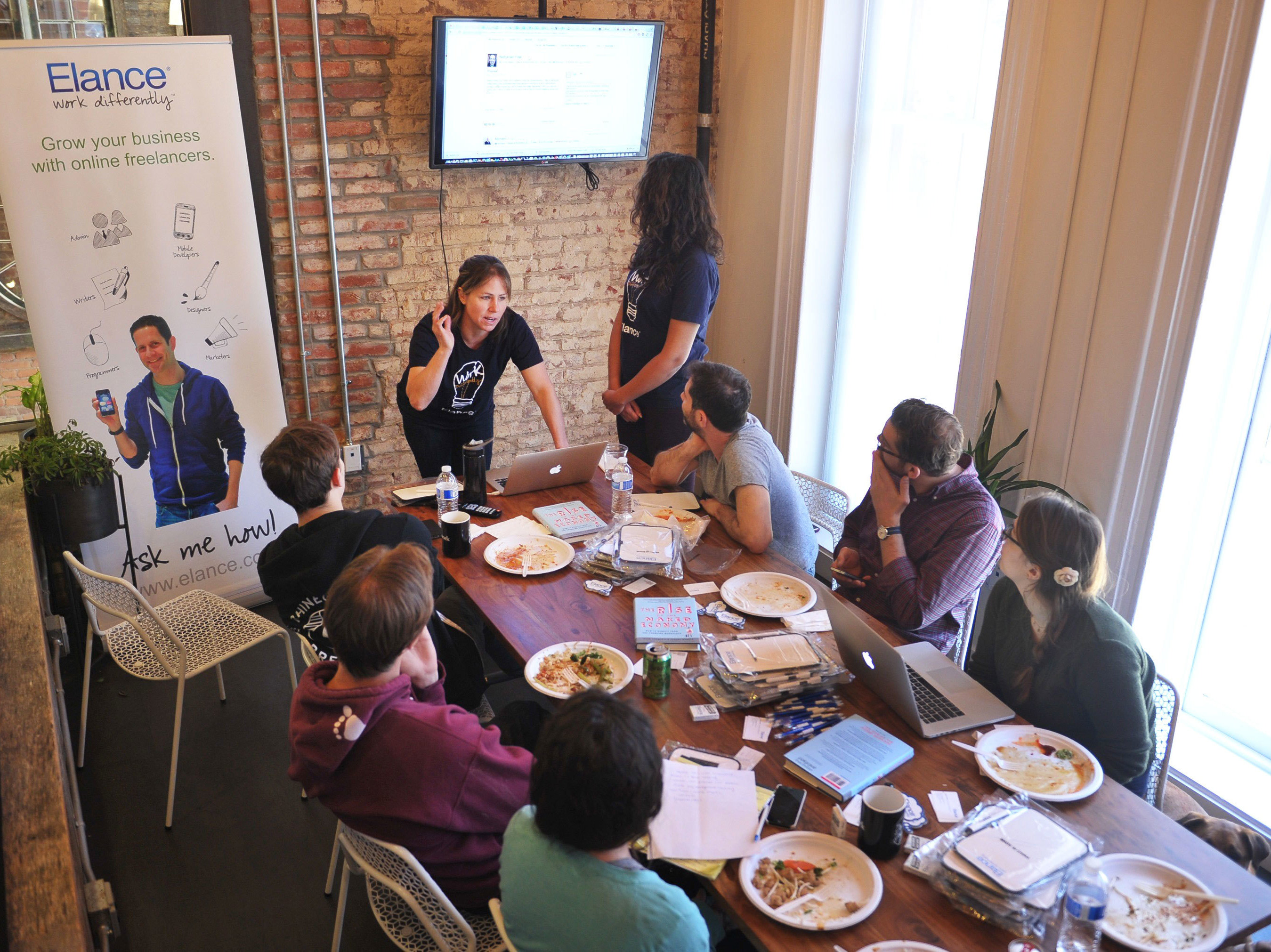 People gather around a speaker during a lunchtime seminar at a WeWork co-working space in Washington, D.C. (AFP/Getty Images)