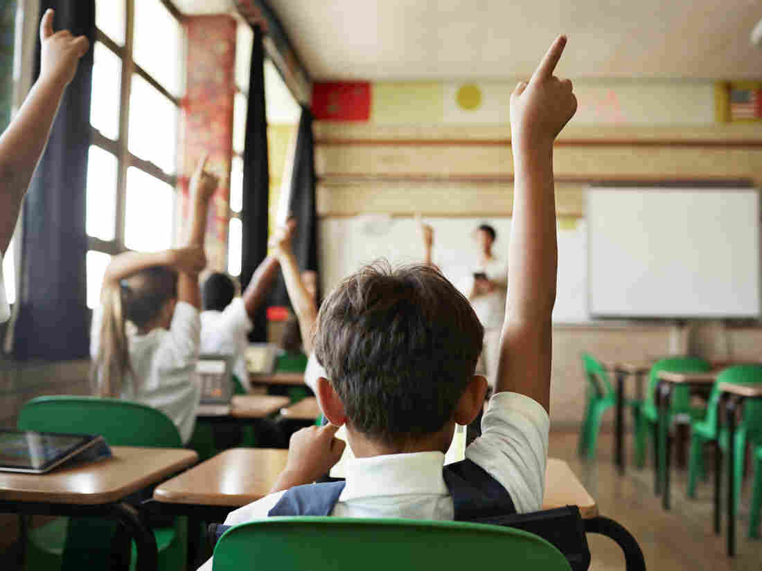 School children in uniforms in class with tablets