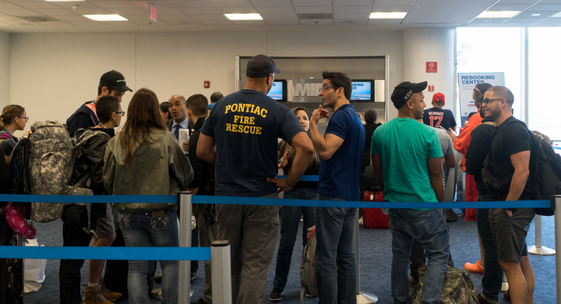First responders and travelers wait in line at Miami International Airport to be rebooked after their 7:20 a.m. Saturday flight to Puerto Rico was canceled. Many are trying to reach those affected by the destructive path of Hurricane Maria. (Angel Valentin for NPR)
