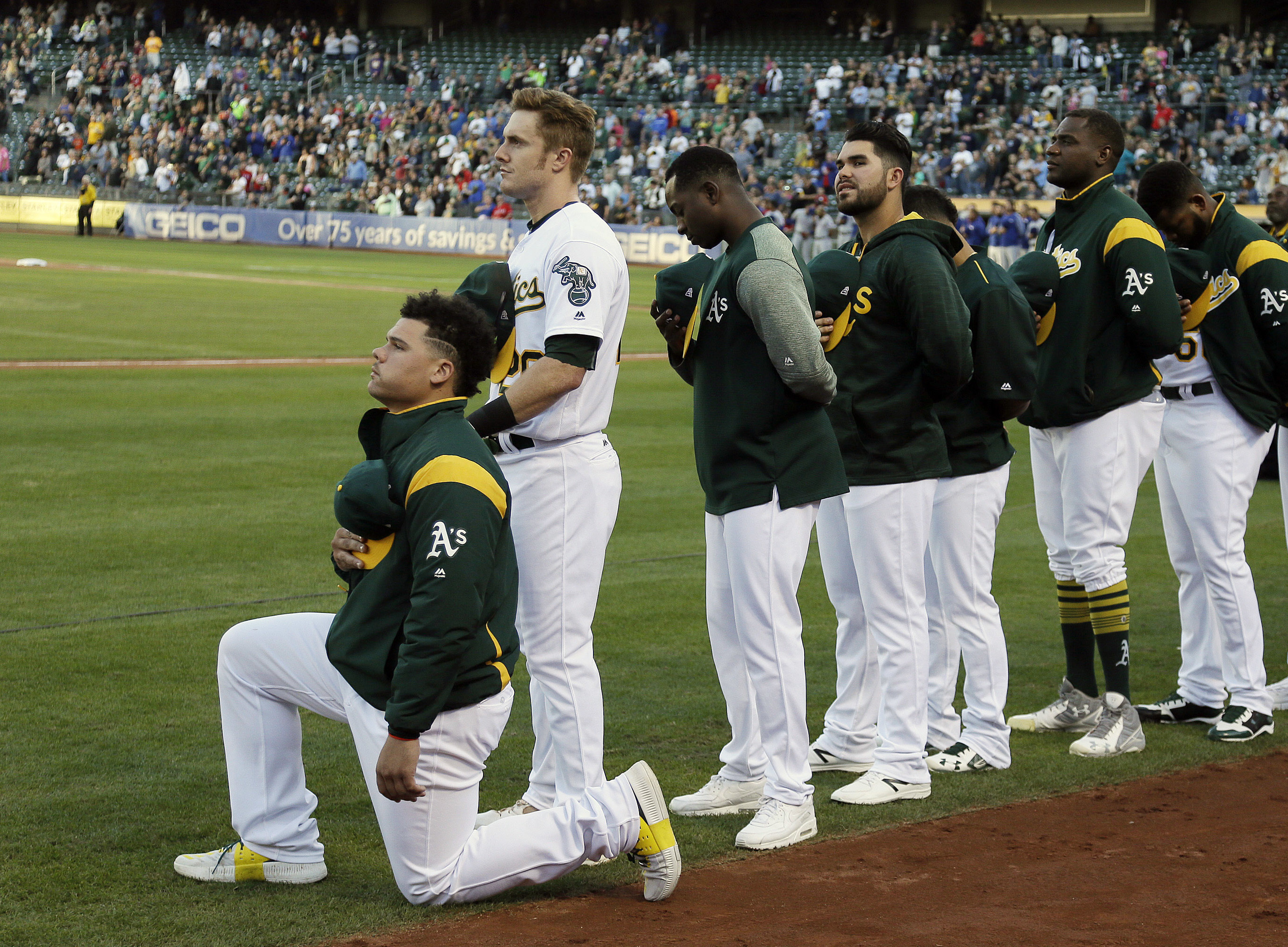 Oakland Athletics catcher Bruce Maxwell kneels during the national anthem Saturday in Oakland. Maxwell is the first Major League Baseball player to kneel during the national anthem. (Eric Risberg/AP)