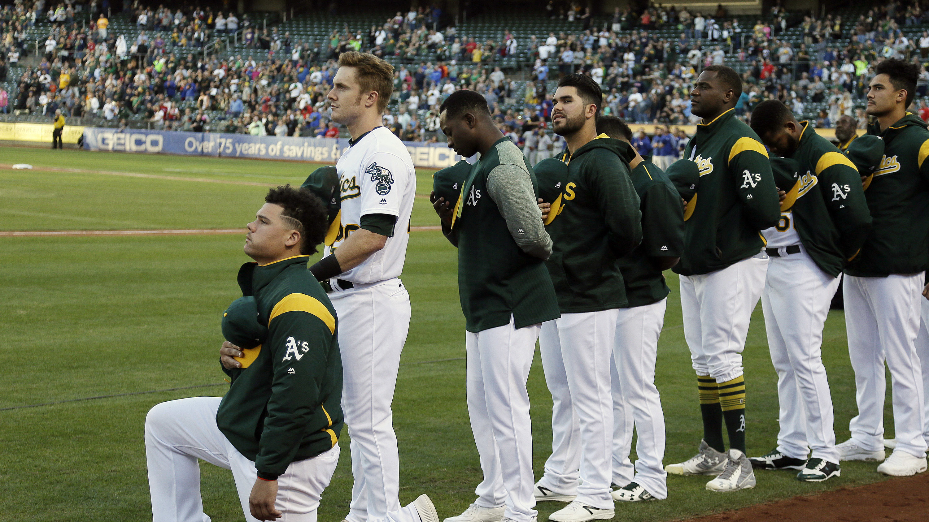 Oakland Athletics catcher Bruce Maxwell kneels during the national anthem Saturday in Oakland. Maxwell is the first Major League Baseball player to kneel during the national anthem.