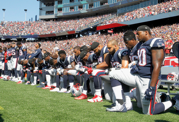 Members of the New England Patriots — and players across the league — kneel during the national anthem before Sunday's game against the Houston Texans.