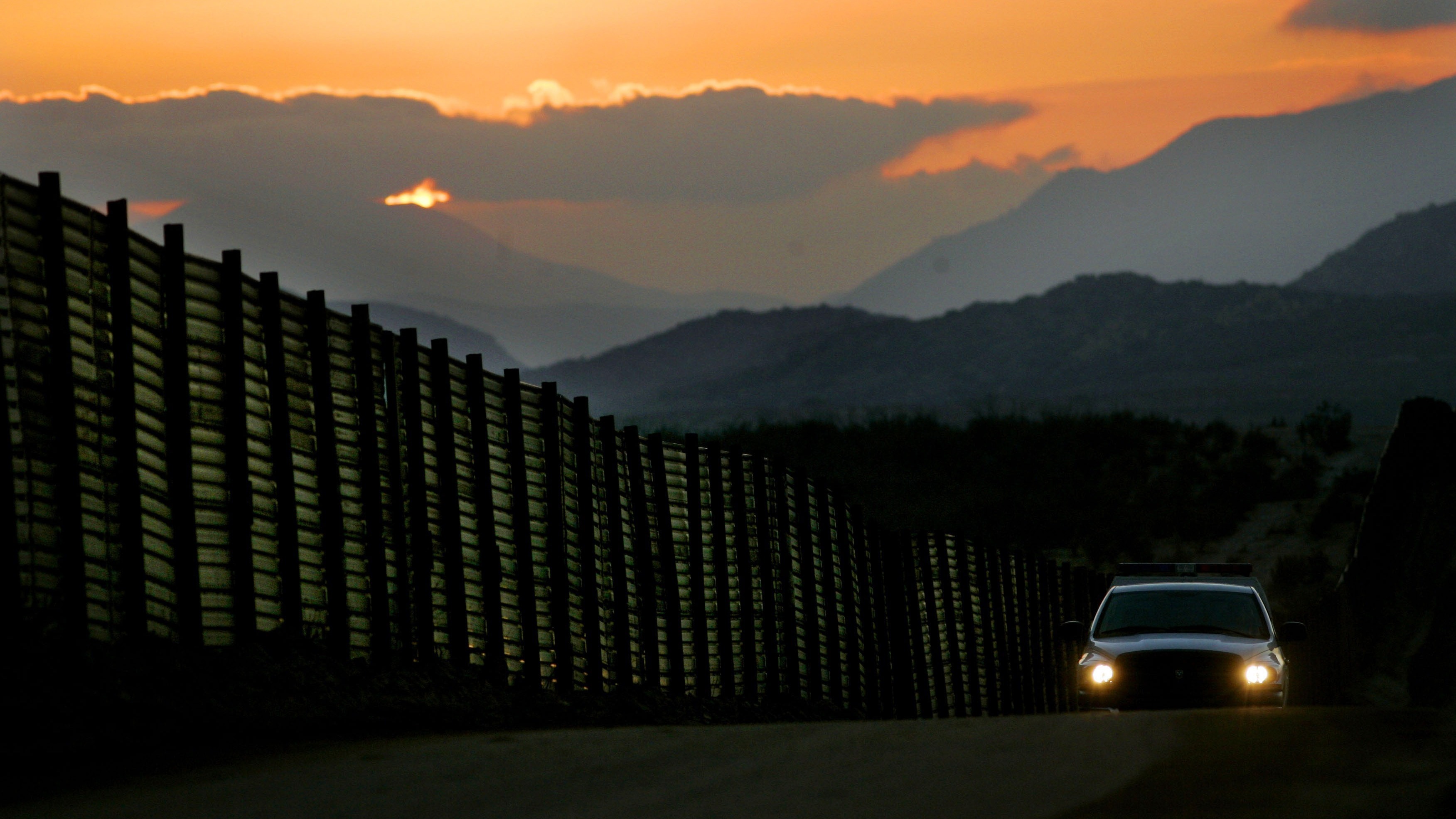 A Border Patrol vehicle rides beside an already existing portion of the wall along the U.S.-Mexico border south of San Diego. (Getty Images)