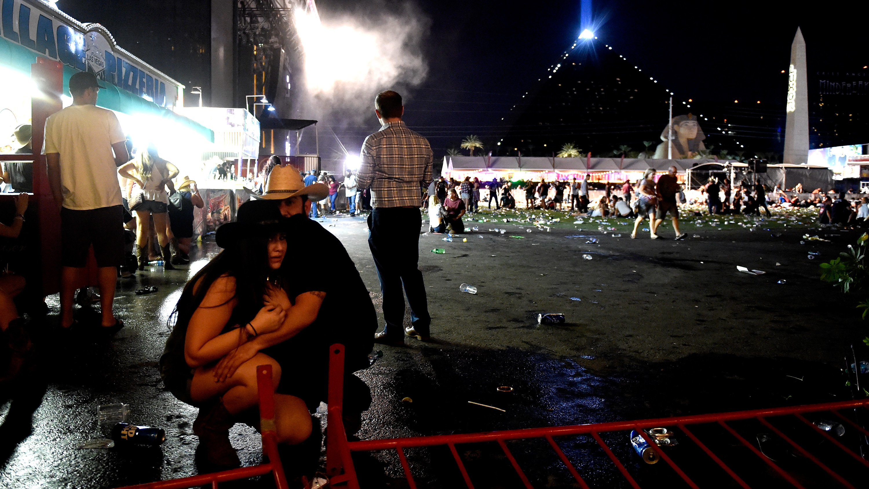 People take cover at the Route 91 Harvest festival after a gunman opened fire on the festival from a room in the Mandalay Bay Resort and Casino in Las Vegas. (Getty Images)