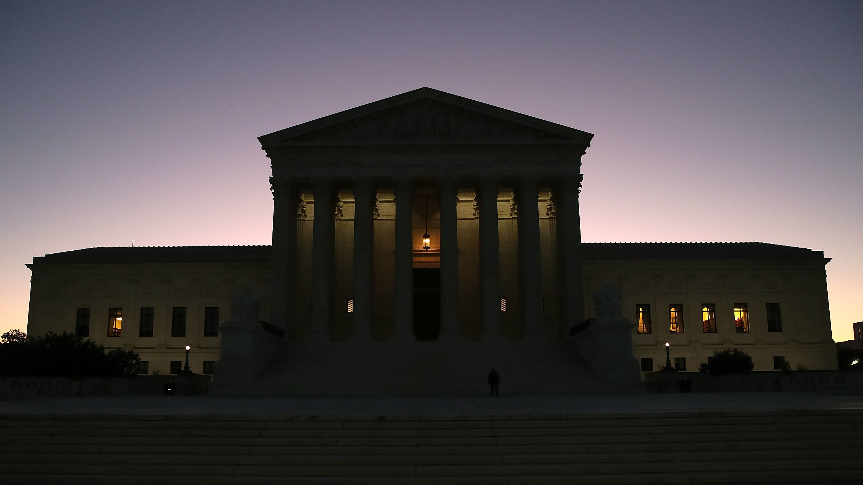The sun begins to rise behind the U.S. Supreme Court on Monday, the first day of the high court's new session. (Getty Images)