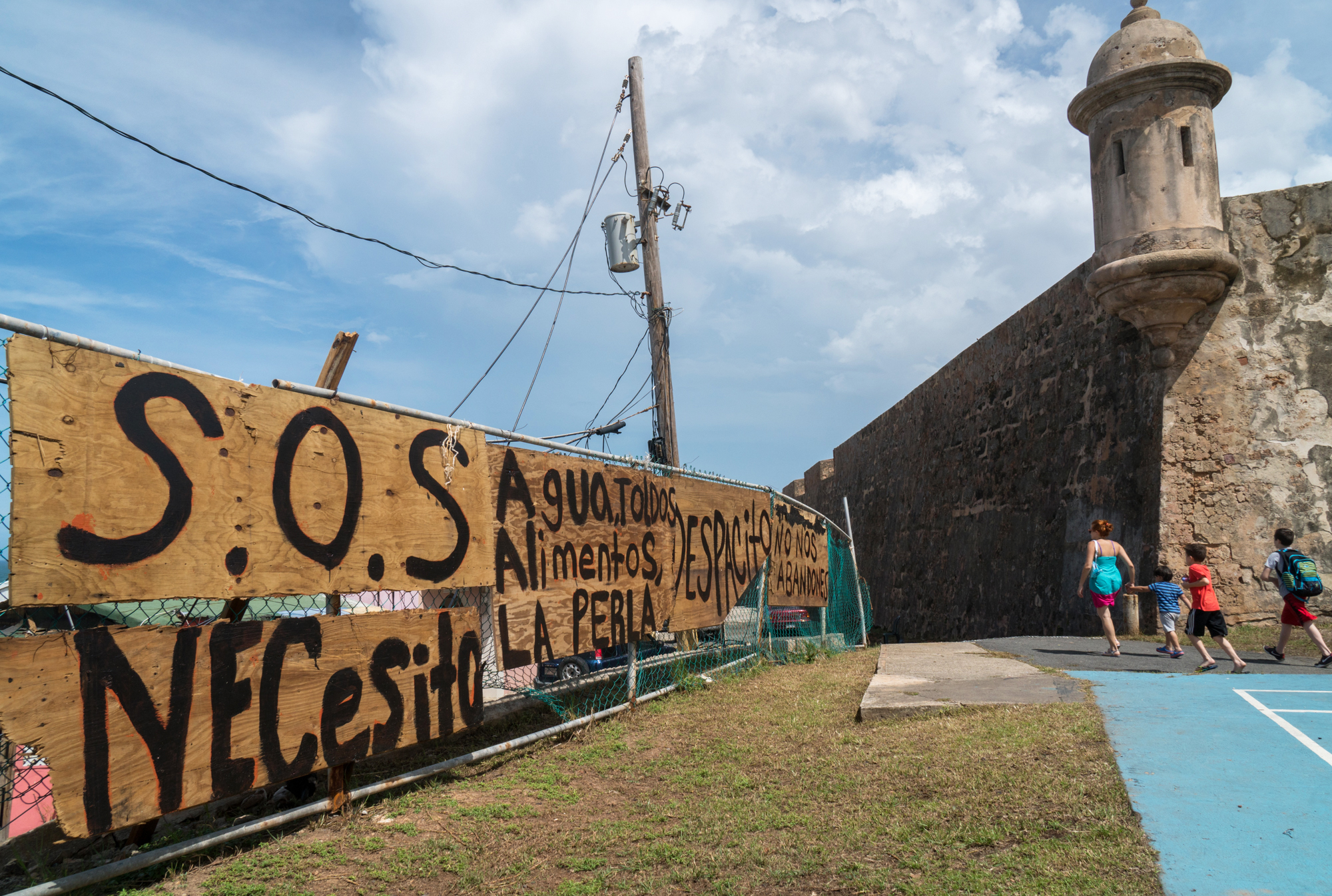 Residents set up signs asking for help in the basketball court of La Perla neighborhood in Old San Juan, Puerto Rico after Hurricane Maria's destruction. La Perla is where the &quot;Despacito&quot; video was filmed. (Angel Valentin for NPR)