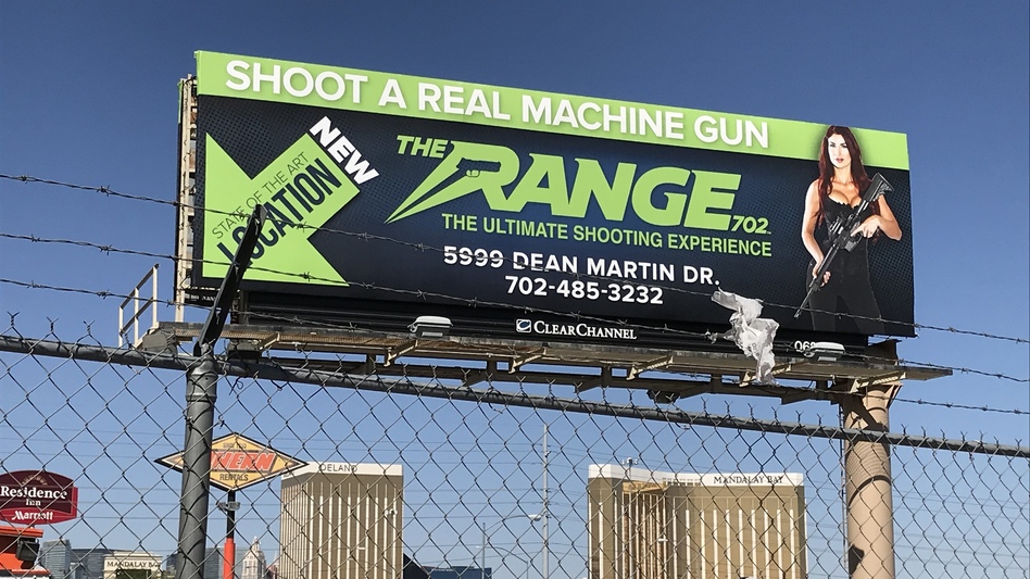 A billboard advertising a gun tourism business in Las Vegas hovers above the Mandalay Bay Hotel, site of a mass shooting Sunday night that killed 58 people and injured nearly 500. (Monika Evstatieva/NPR)