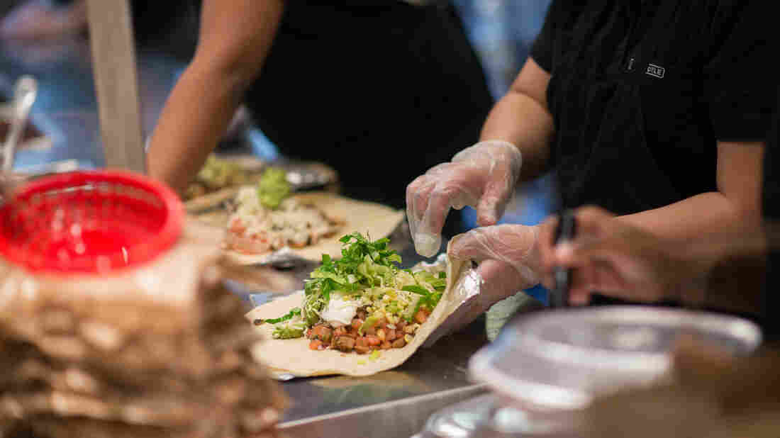 Employees prepare lunch orders at a Chipotle Mexican Grill restaurant at Madison Square Park in New York, U.S., on Wednesday, Jan. 29, 2014. Chipotle Mexican Grill Inc. is expected to release earnings figures on Jan. 30. Photographer: Craig Warga/Bloomberg via Getty Images