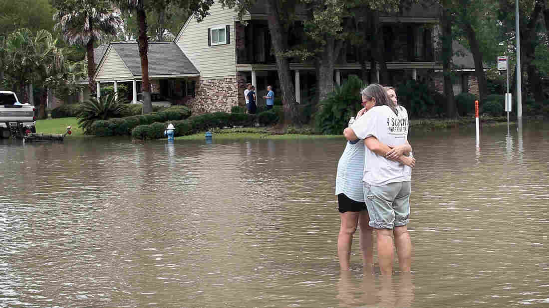 HOUSTON, TX - AUGUST 30: Friends reunite in the middle of a flooded intersection as water continues to rise in their neighborhood following Hurricane Harvey on August 30, 2017 in Houston, Texas. Harvey, which made landfall north of Corpus Christi August 25, has dumped nearly 50 inches of rain in and around Houston. (Photo by Scott Olson/Getty Images)