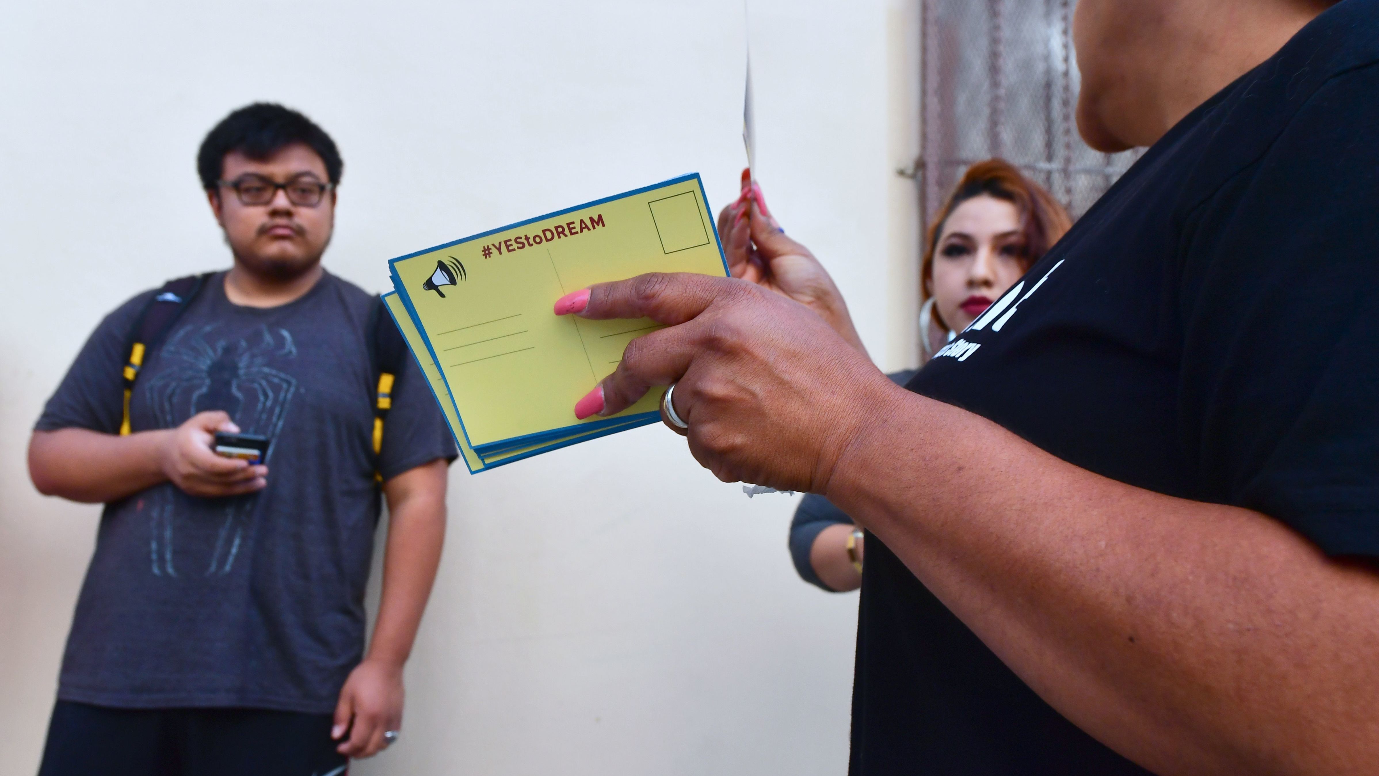 Volunteers offer cards to be filled out and sent to members of the House of Representatives as Deferred Action for Childhood Arrivals (DACA) recipients wait in line at the Coalition for Humane Immigrant Rights (CHIRLA) office in Los Angeles on September 30, 2017. (AFP/Getty Images)