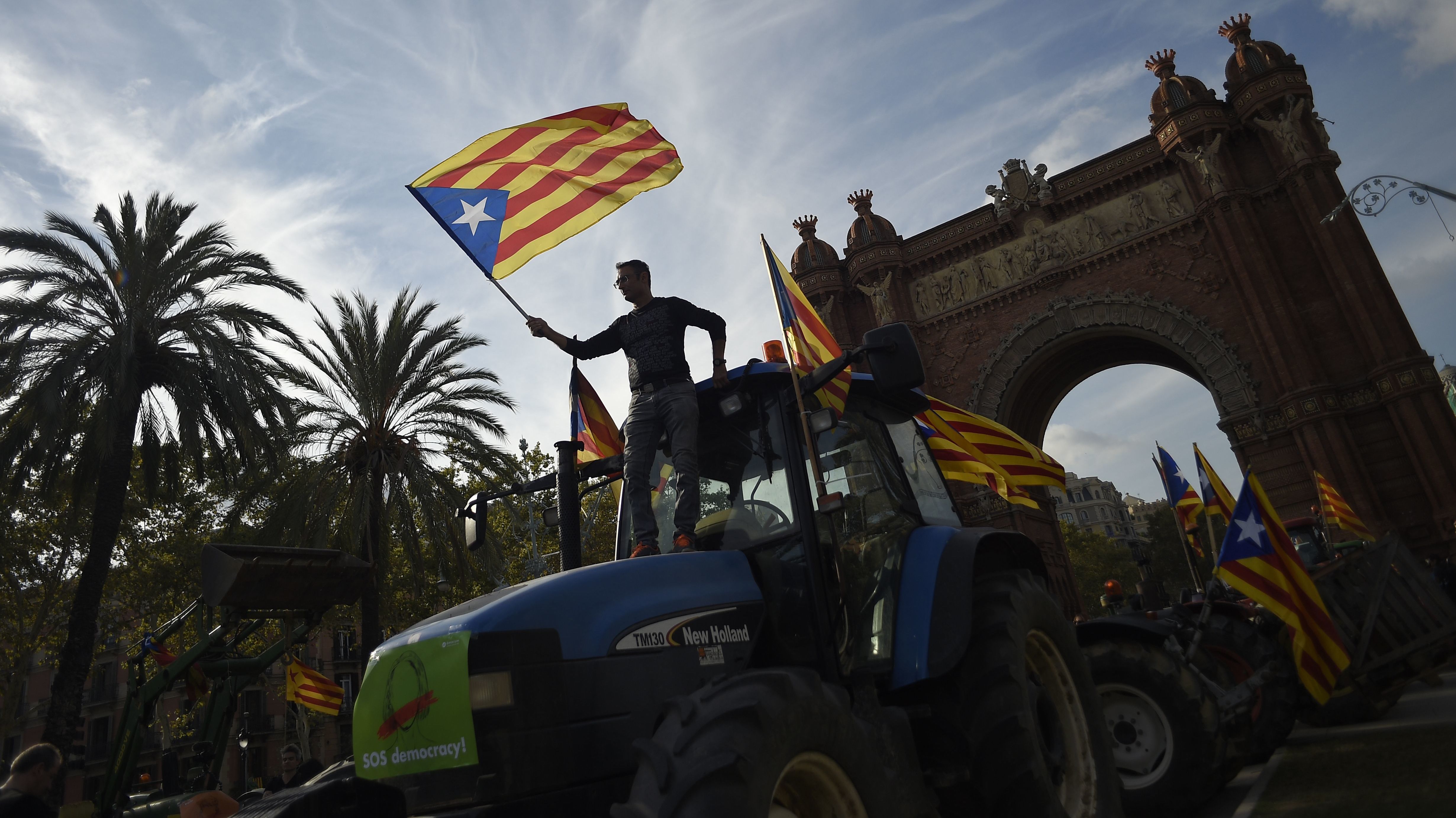 Supporters of Catalan independence wave Catalan flags as they drive with tractors through the Arc de Triomf in Barcelona on Tuesday.