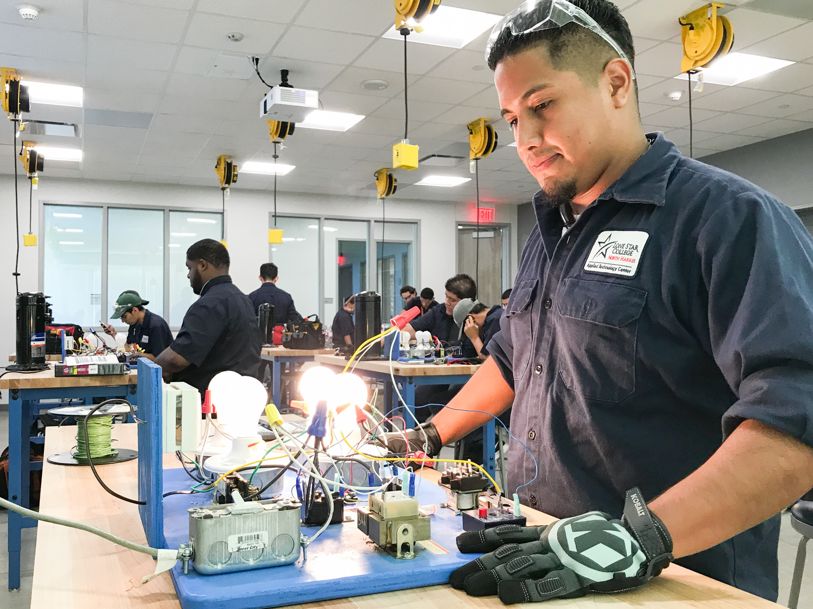 Eric Arjon practices on a circuit board at Lone Star College's new construction trades center in Houston. He is training to become a heating, ventilation and air conditioning technician. (NPR)