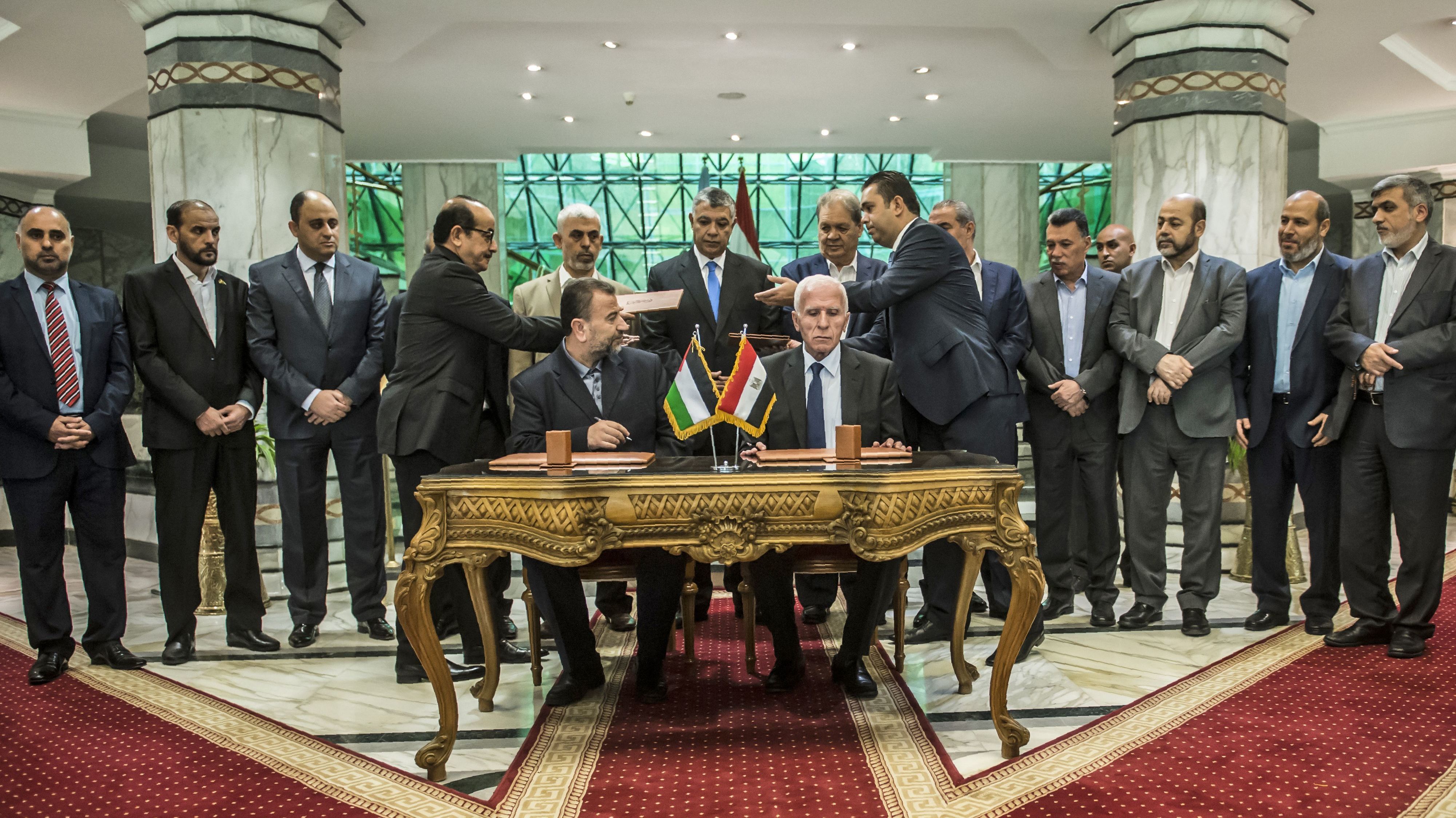 Senior Hamas leader Saleh al-Arouri (left) sits next to Fatah's Azzam al-Ahmad as they sign a reconciliation deal in Cairo on Thursday. Under the agreement, Hamas would cede control of the Gaza Strip to the Fatah-led Palestinian Authority by Dec. 1. (AFP/Getty Images)
