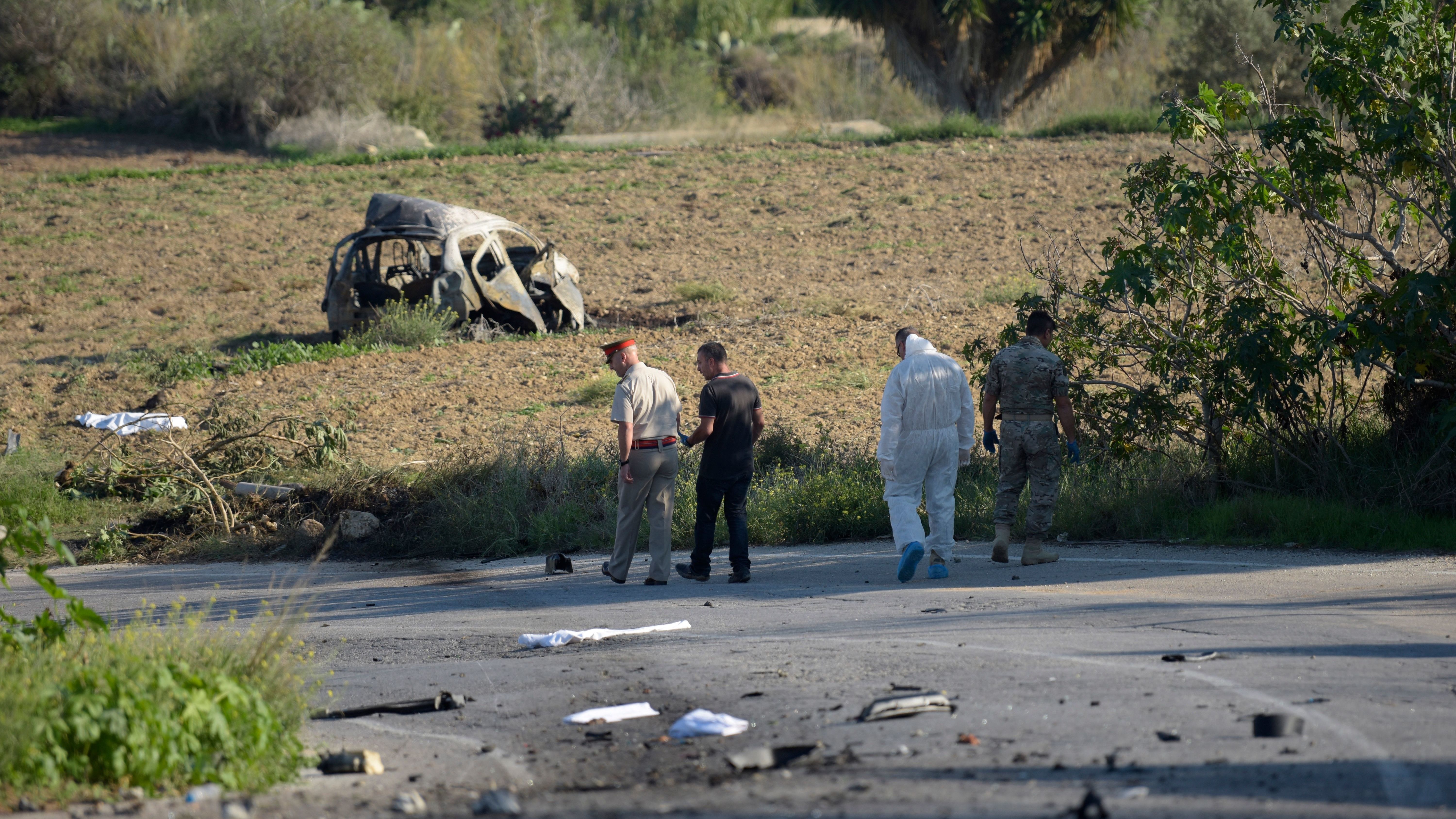 Police and forensic experts inspect the wreckage of a car bomb believed to have killed journalist Daphne Caruana Galizia close to her home in Bidnija, Malta, on Monday. The force of the blast broke her car into several pieces, witnesses said. (AFP/Getty Images)