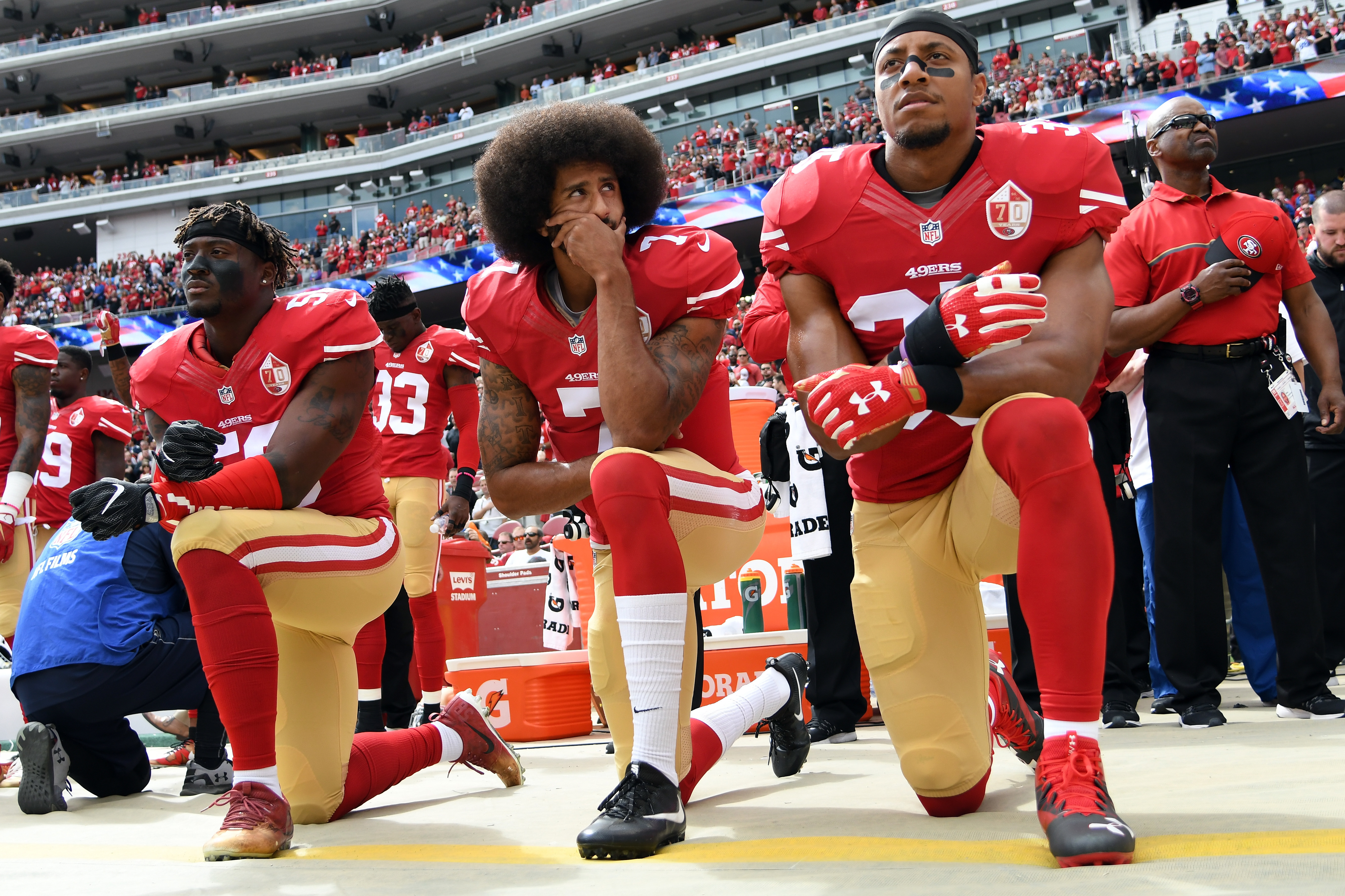 Former San Francisco 49ers quarterback Colin Kaepernick (middle) knelt on the sidelines during the national anthem to protest what he saw as the oppression of African-Americans in the United States. (Getty Images)