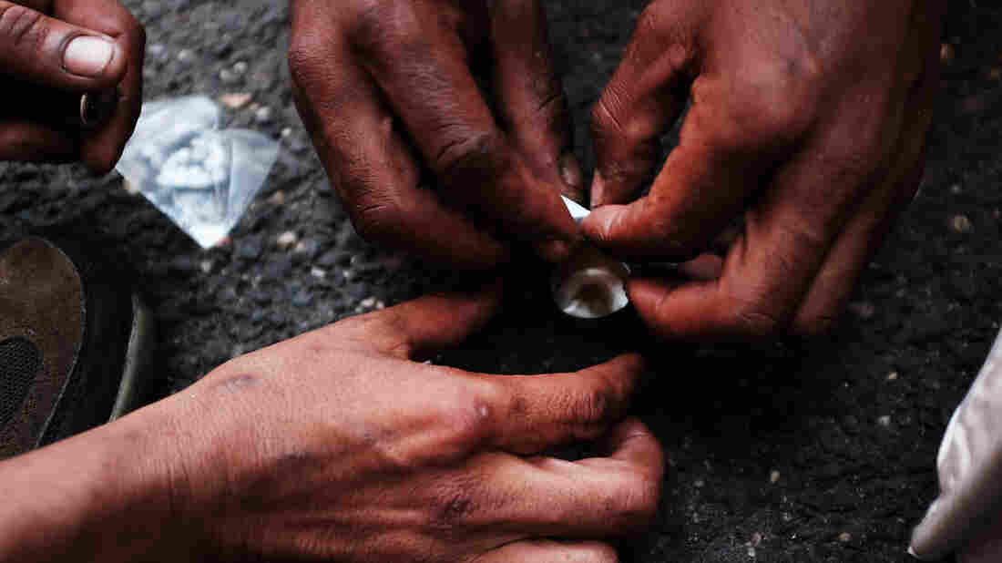 Heroin users in New York City prepare to shoot up on the street.