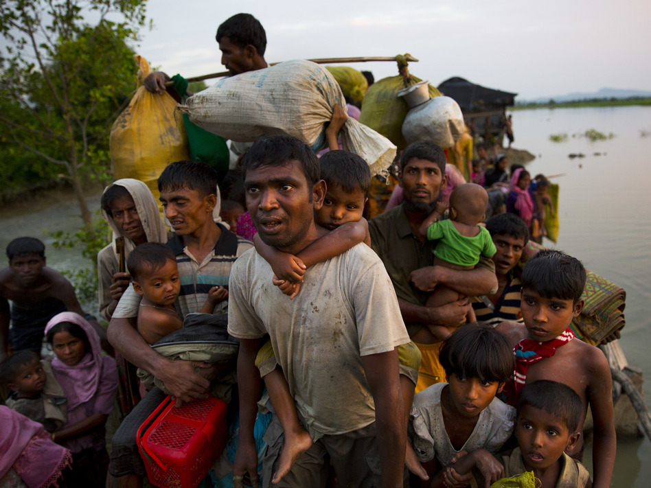 Rohingya Muslims carry their young children and belongings after crossing the border from Myanmar into Bangladesh, near Palong Khali, Bangladesh, on Wednesday. (Bernat Armangue/AP)