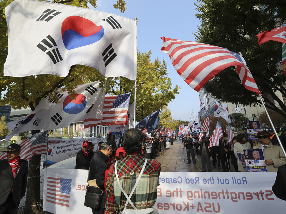 South Koreans hold flags during a rally welcoming U.S. President Donald Trump's visit to the country in downtown Seoul, South Korea, on Friday. (Lee Jin-man/AP)