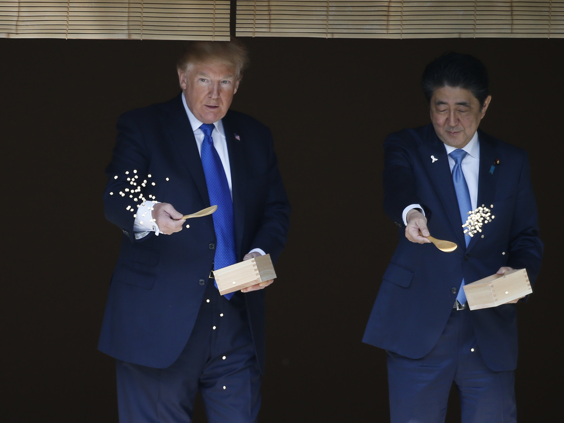 President Donald Trump and Japanese Prime Minister Shinzo Abe feed koi fish during a welcoming ceremony in Tokyo on Monday. (AFP/Getty Images)