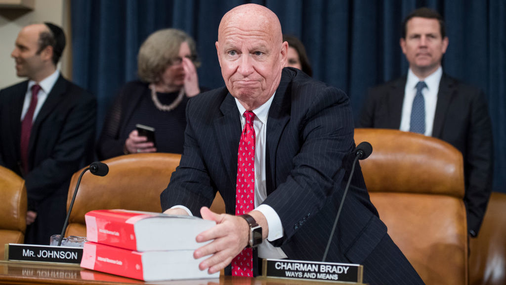 House Ways and Means Committee Chairman Kevin Brady, R-Texas, places books of the current tax code on the dais during Monday's markup of the Republicans' tax overhaul plan. (CQ Roll Call Inc./Getty Images)