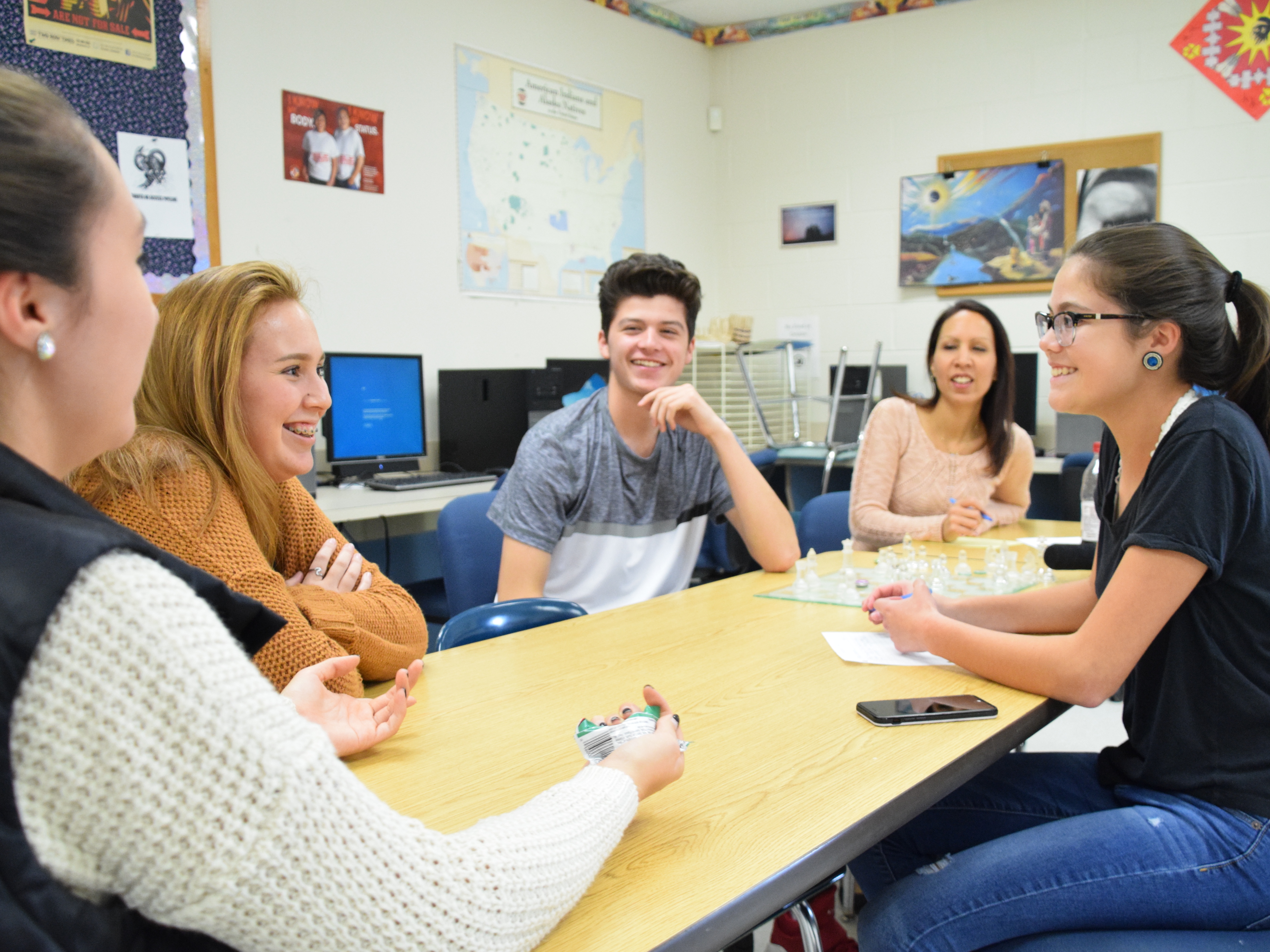 Mohawk Club adviser Robin Logan (in back) watches as club members Amanda Rourke (from left), Keely Thompson-Cook, Landon Laffin and Mallory Sunday discuss their high school's Native American Day celebration. (North Country Public Radio)