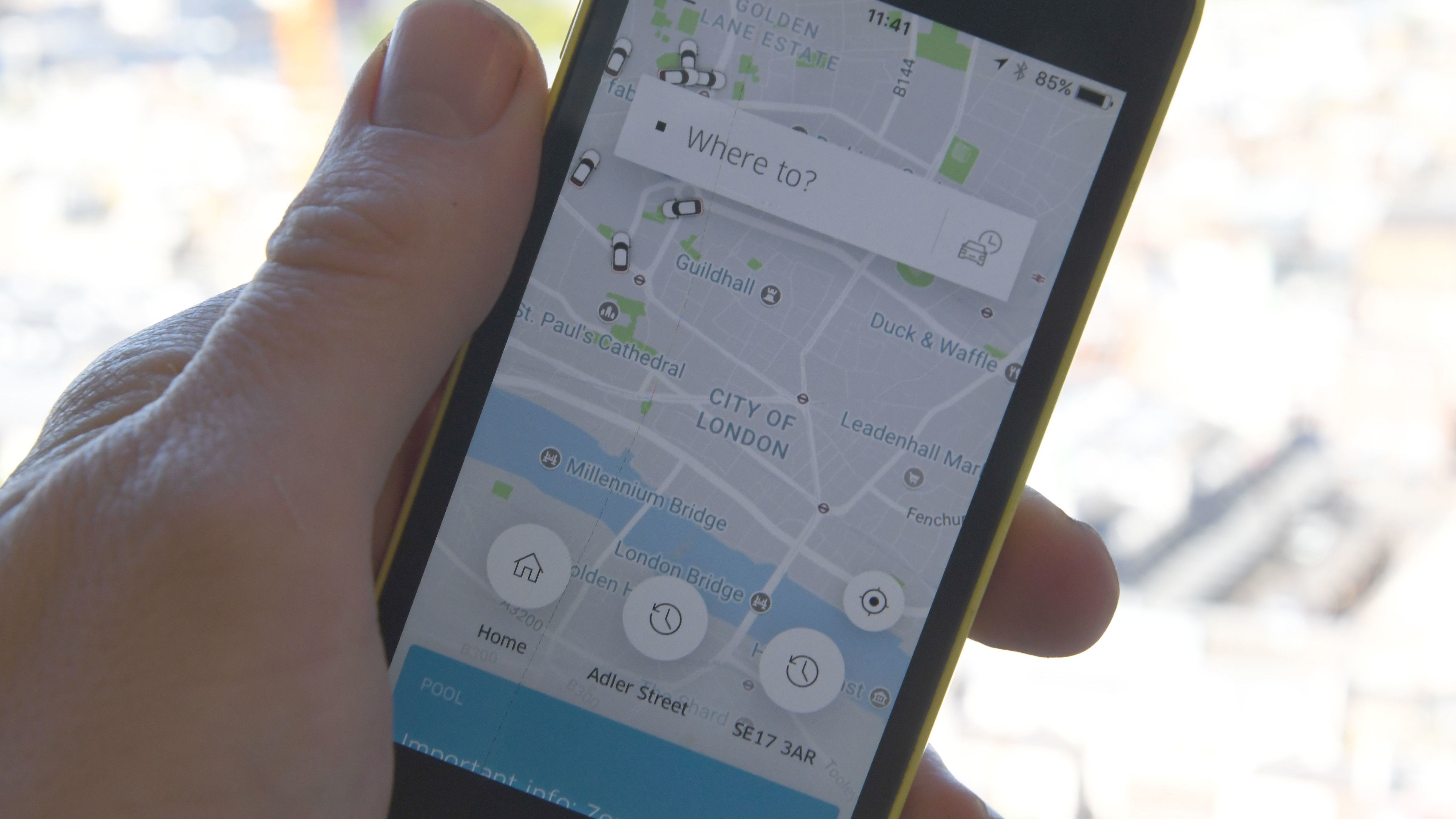A man holds a smartphone showing the Uber app in London. In September, London transport authorities announced they would not renew Uber's license to operate in the city for safety reasons; on Friday, Uber lost an appeal of a British tribunal decision that its drivers are workers who deserve legal protections. (AFP/Getty Images)