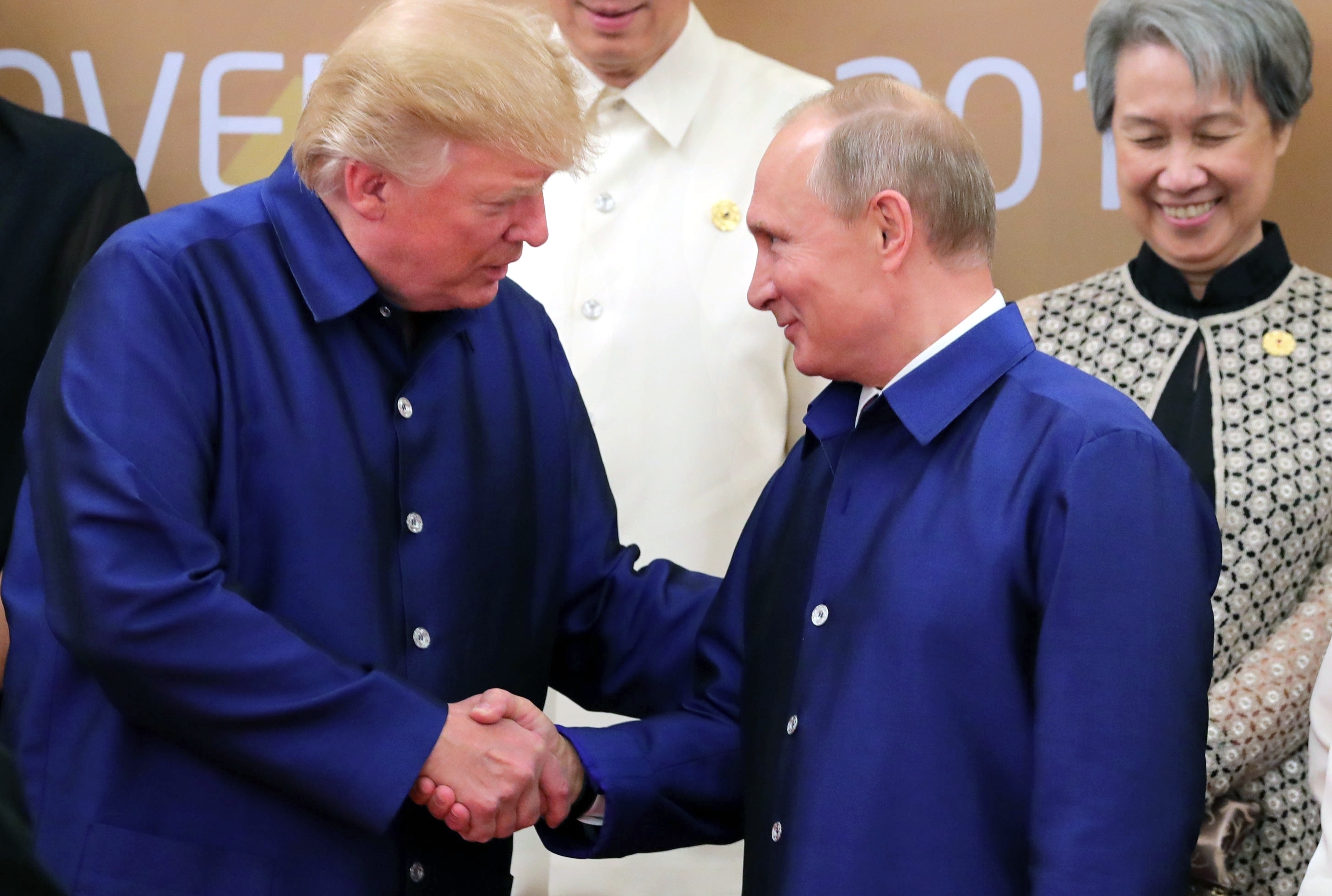 President Trump shakes hands with Russian President Vladimir Putin, as they pose for a group photo ahead of the Asia-Pacific Economic Cooperation Summit leaders gala dinner in Vietnam last week. (AFP/Getty Images)