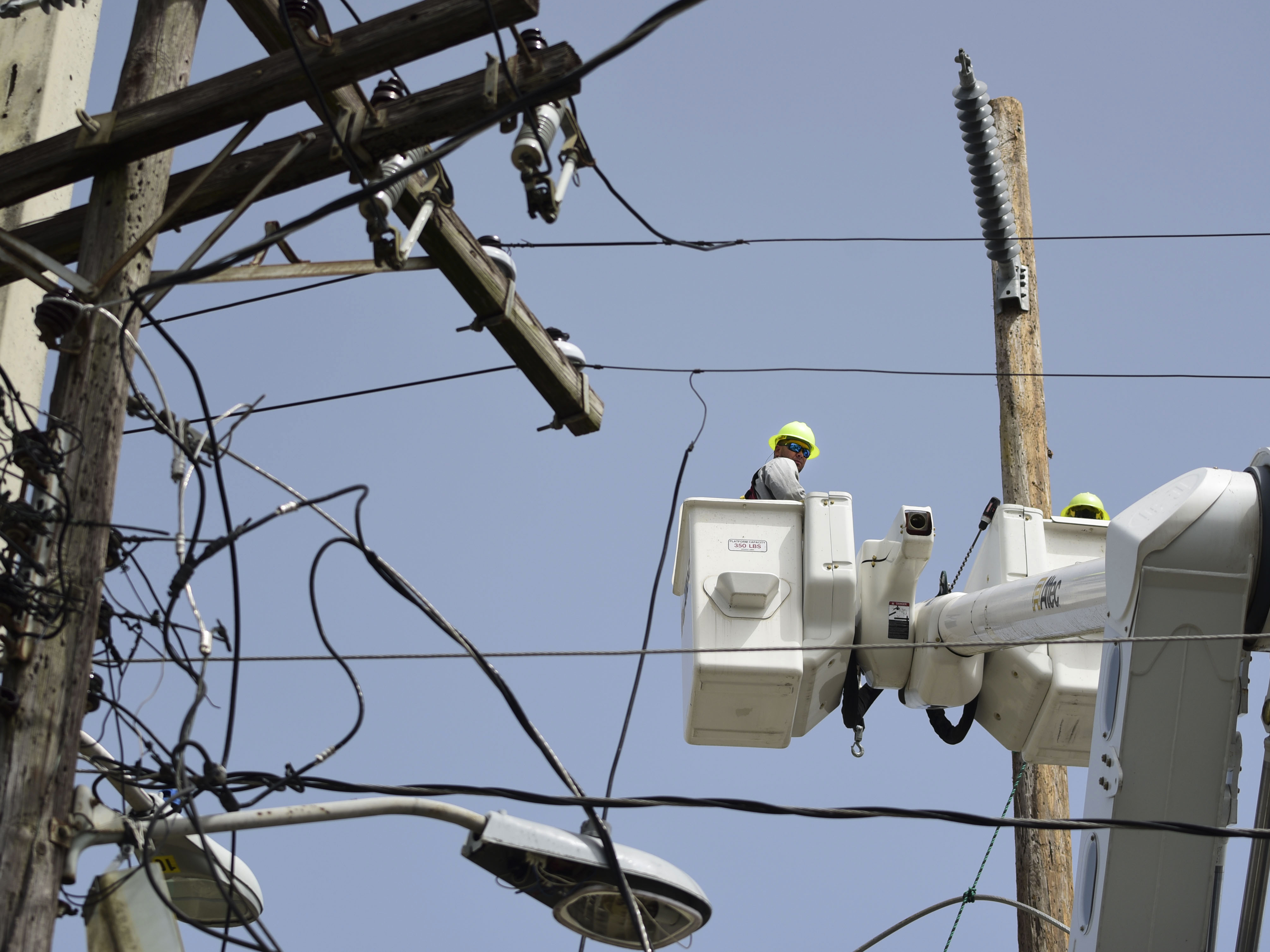 A lineman from the Electric Power Authority repairs distribution lines damaged by Hurricane Maria in Puerto Rico.